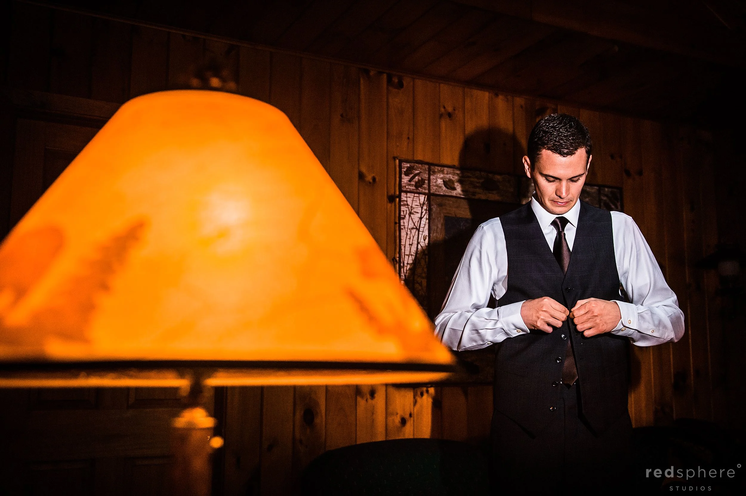 Groom Buttoning up His Vest Before Heading Out