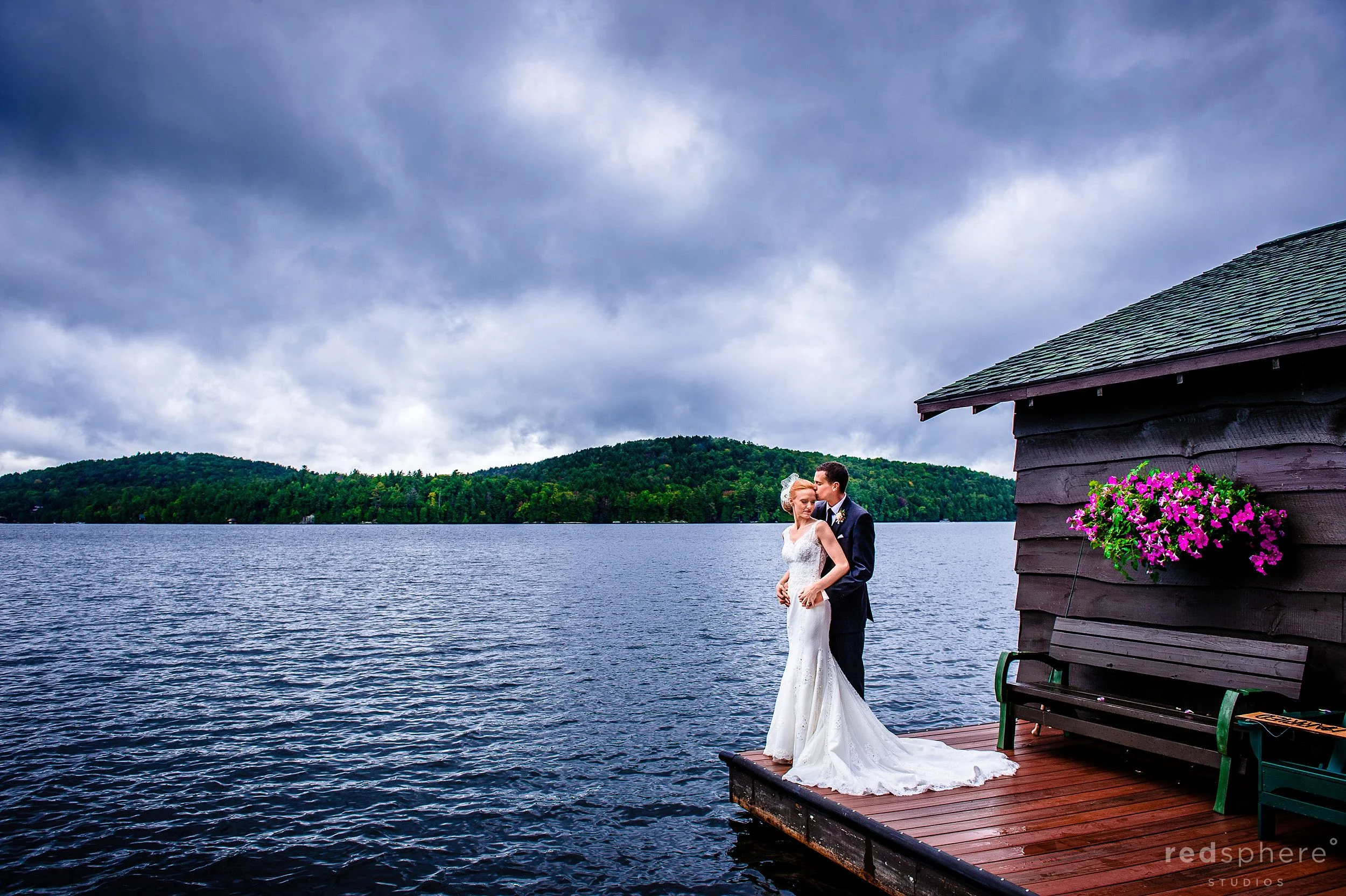 Groom Hugging Bride on Saranac Lake Dock New York