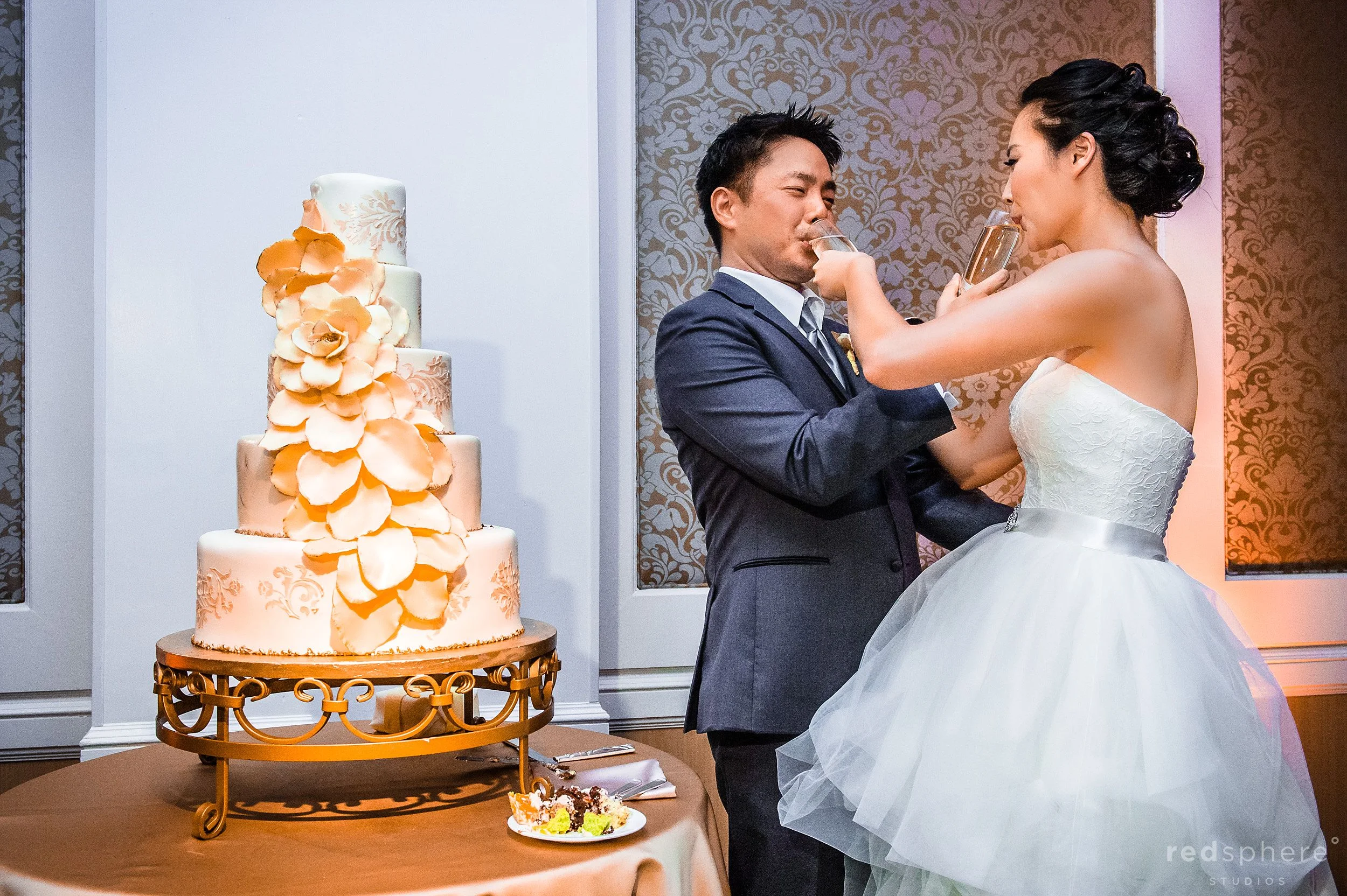 Newly Wed Couple Having Fun With Champagne and Wedding Cake