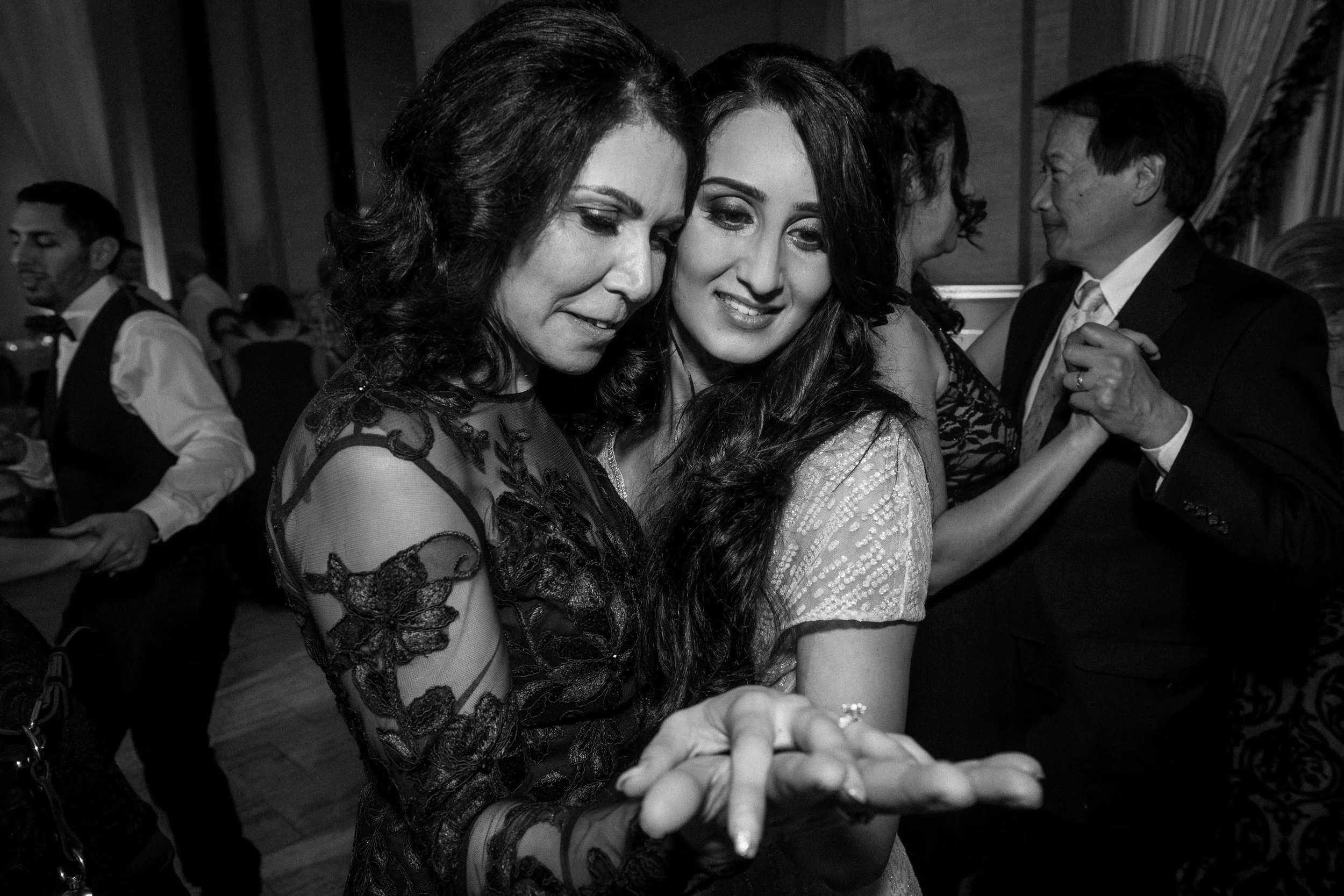 Bride and her mother dancing closely at a wedding reception at Bently Reserve in San Francisco, smiling and holding hands, with other couples in the background.