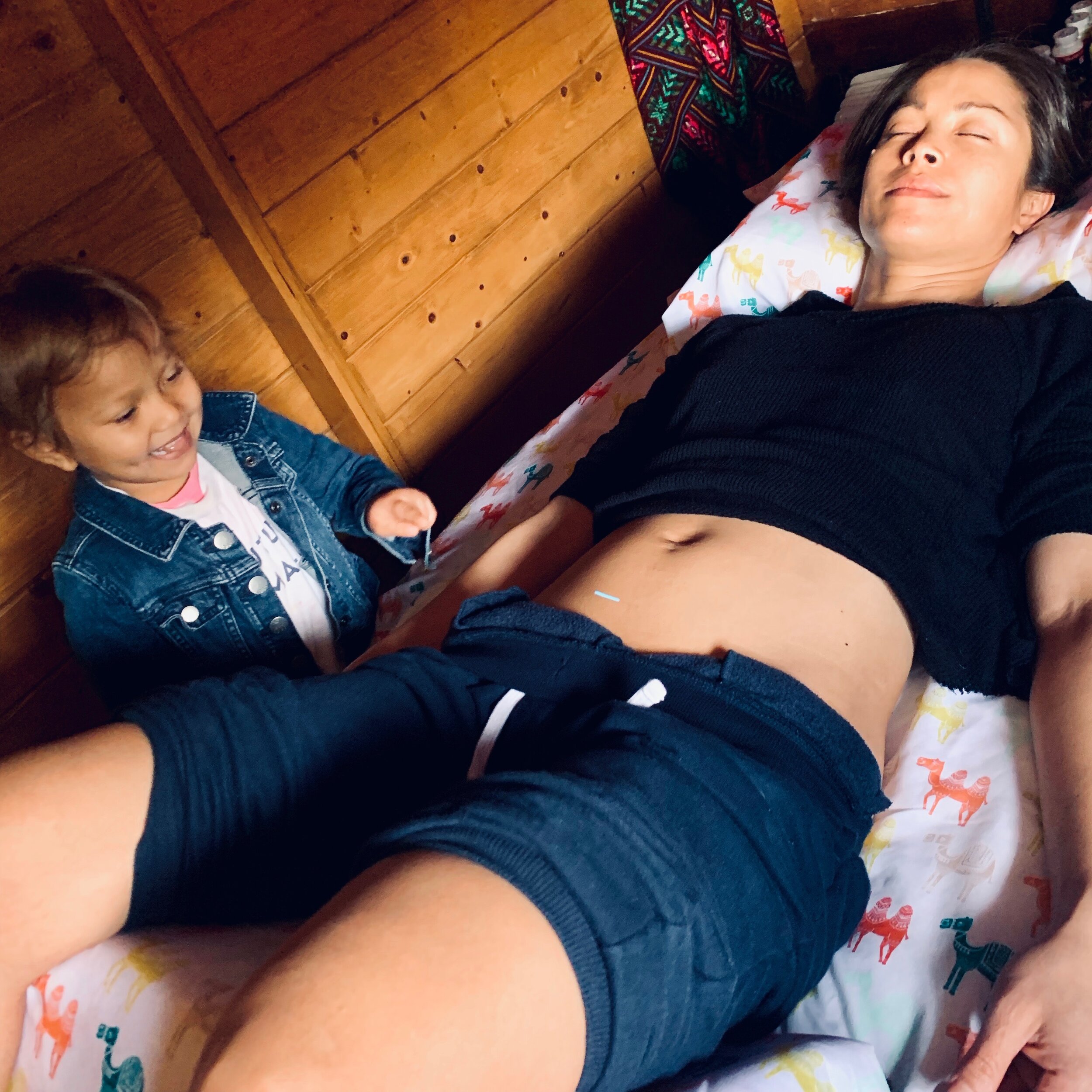 Little Sister points at Mama's Belly during fertility session 