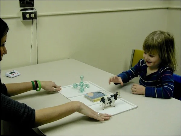A participant and research assistant playing one of our word learning games.