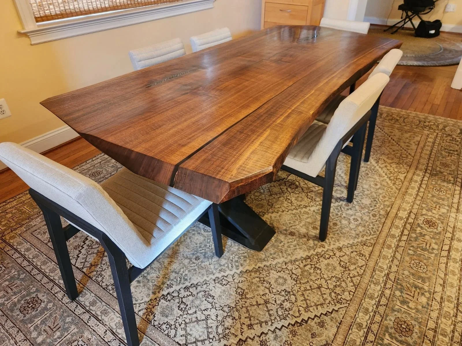 A large figured Walnut dining table with flame finished, sculptural base.
