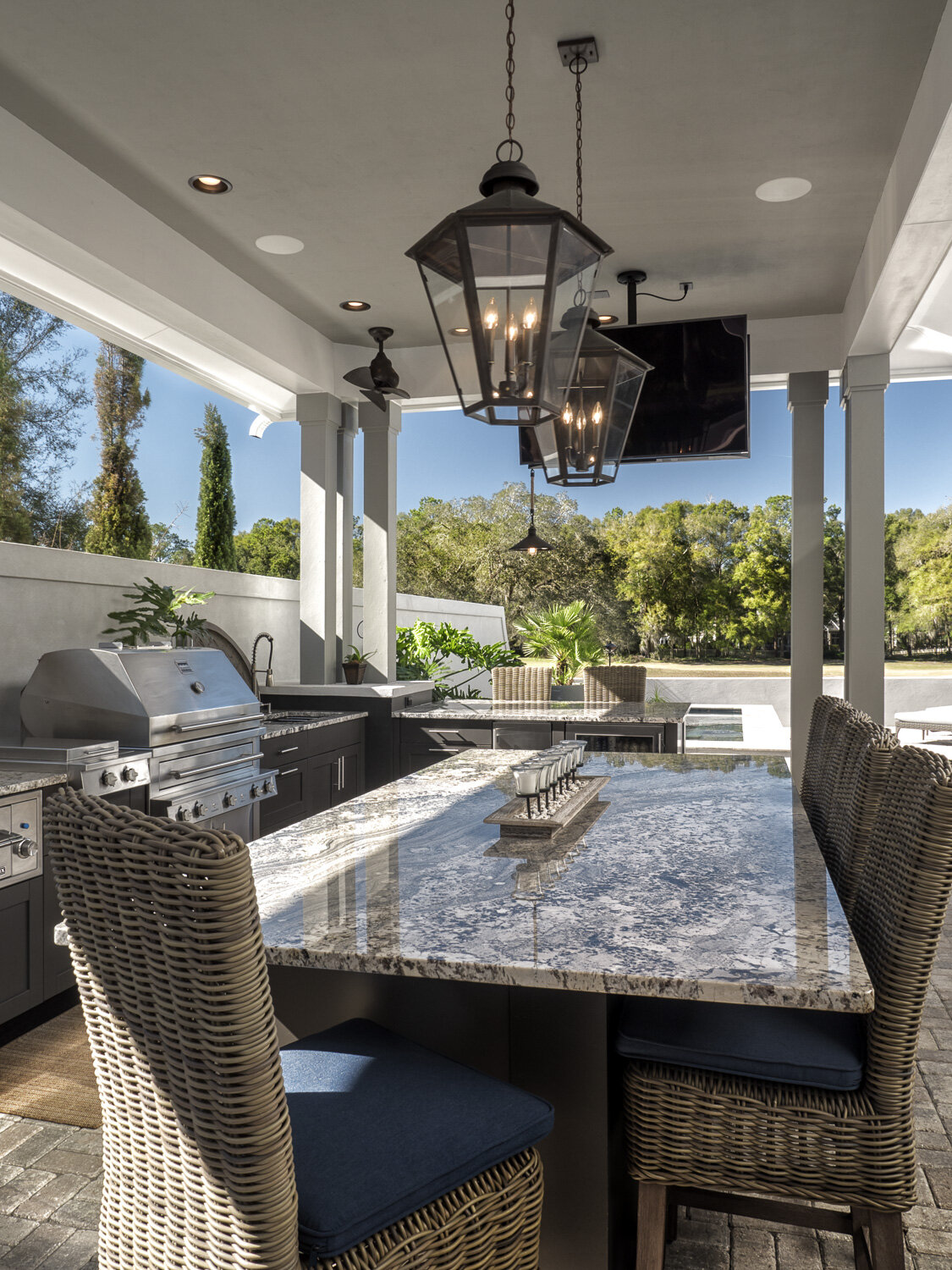 outdoor kitchen design with pendant lights and television