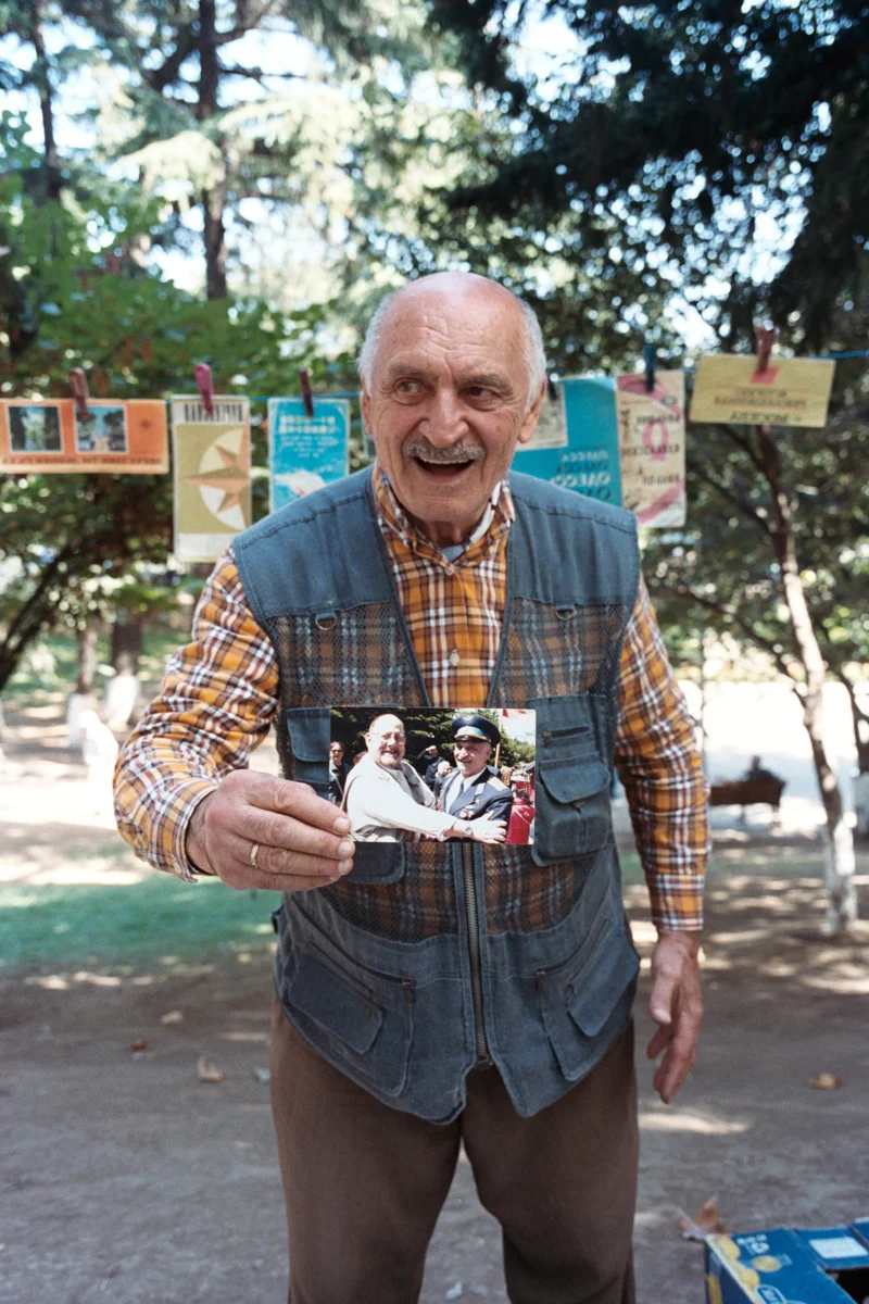 We were admiring this man's collection of Soviet postcards and maps for sale, and I asked to take his photo. He wanted me to take his photo with this prized photo of him in his military uniform meeting a famous politician.