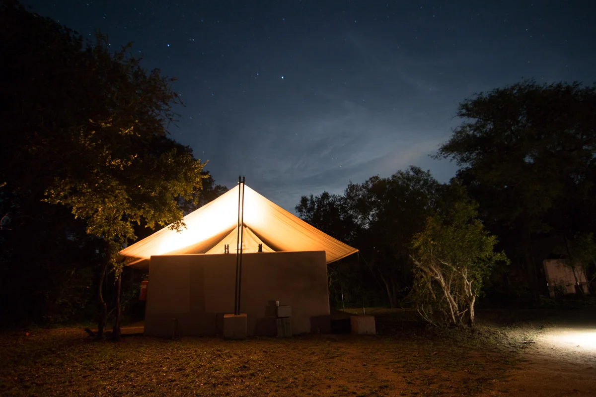 Rear view of our safari tent at night. The moon and stars would shine in so bright I almost had to wear an eyeshade to get to sleep at night. Also through the thin tent walls we could hear an orchestra of the bugs and frogs. Since our camp had no fences separating it from the surrounding reserve we had to be escorted to and from our tent each night so that we didn’t have a surprise encounter with an aggressive buffalo or other wild animal.