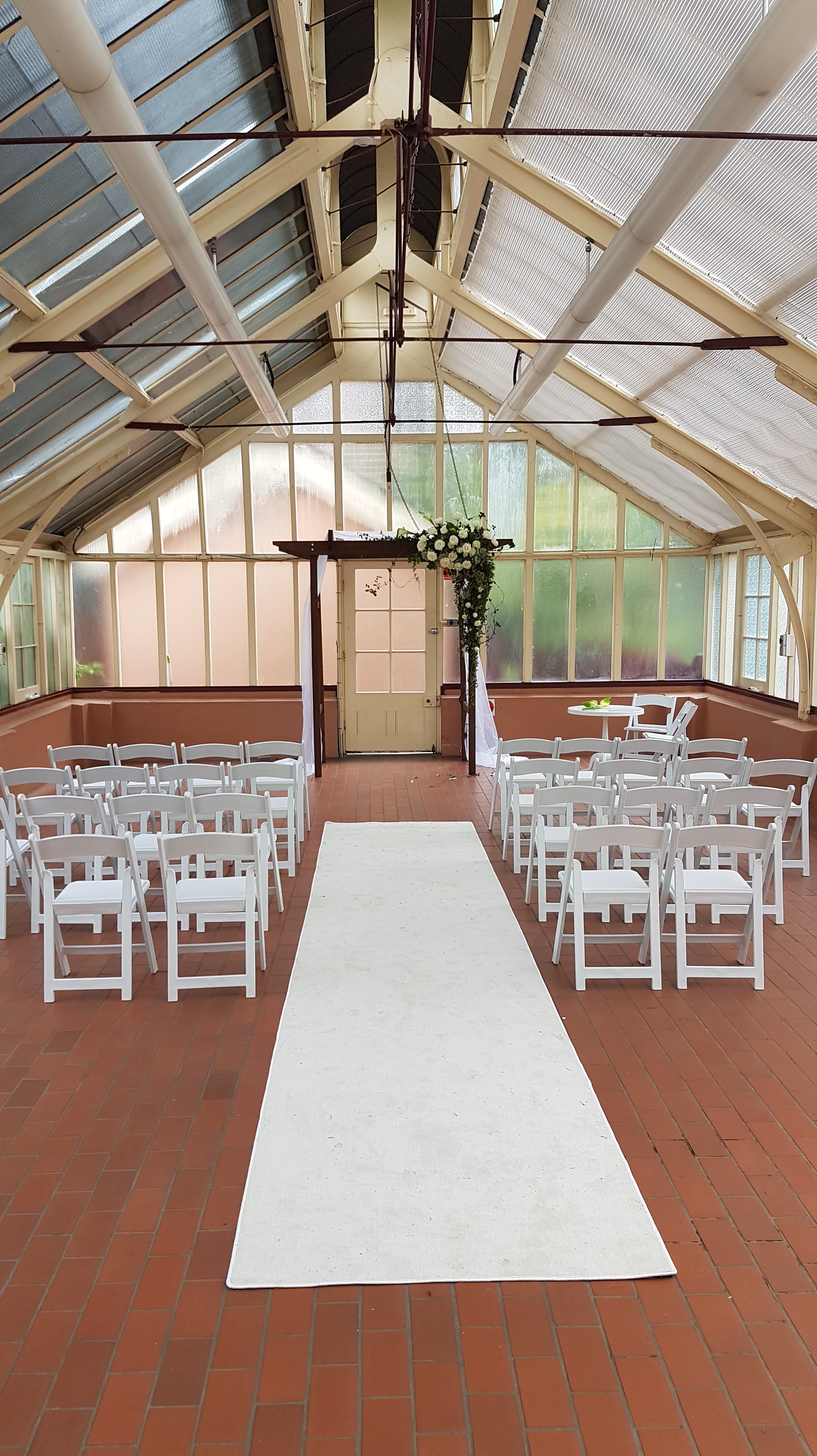 timber arbour with white styling and padded white AMERICANA folding chairs for hire