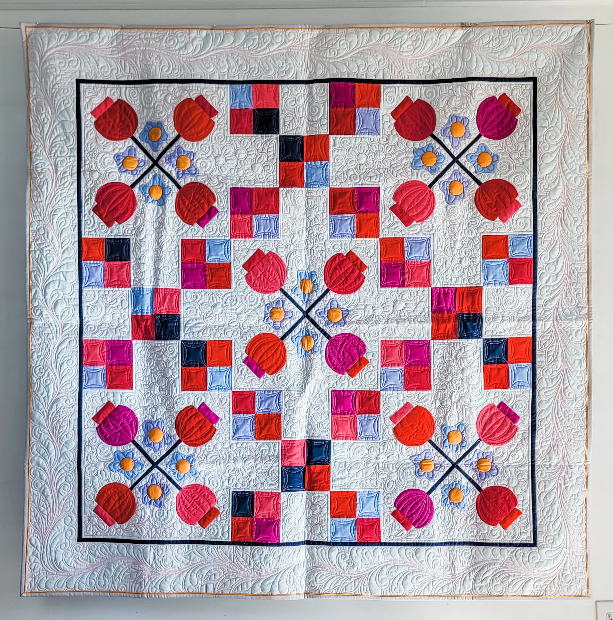 Fuchsia and Forget-me-nots made by Tia Curtis. This quilt features simple 4 blocks and applique as well as some trapunto. I quilted it on my longarm with hot pink thread. This will be a quilt pattern soon.