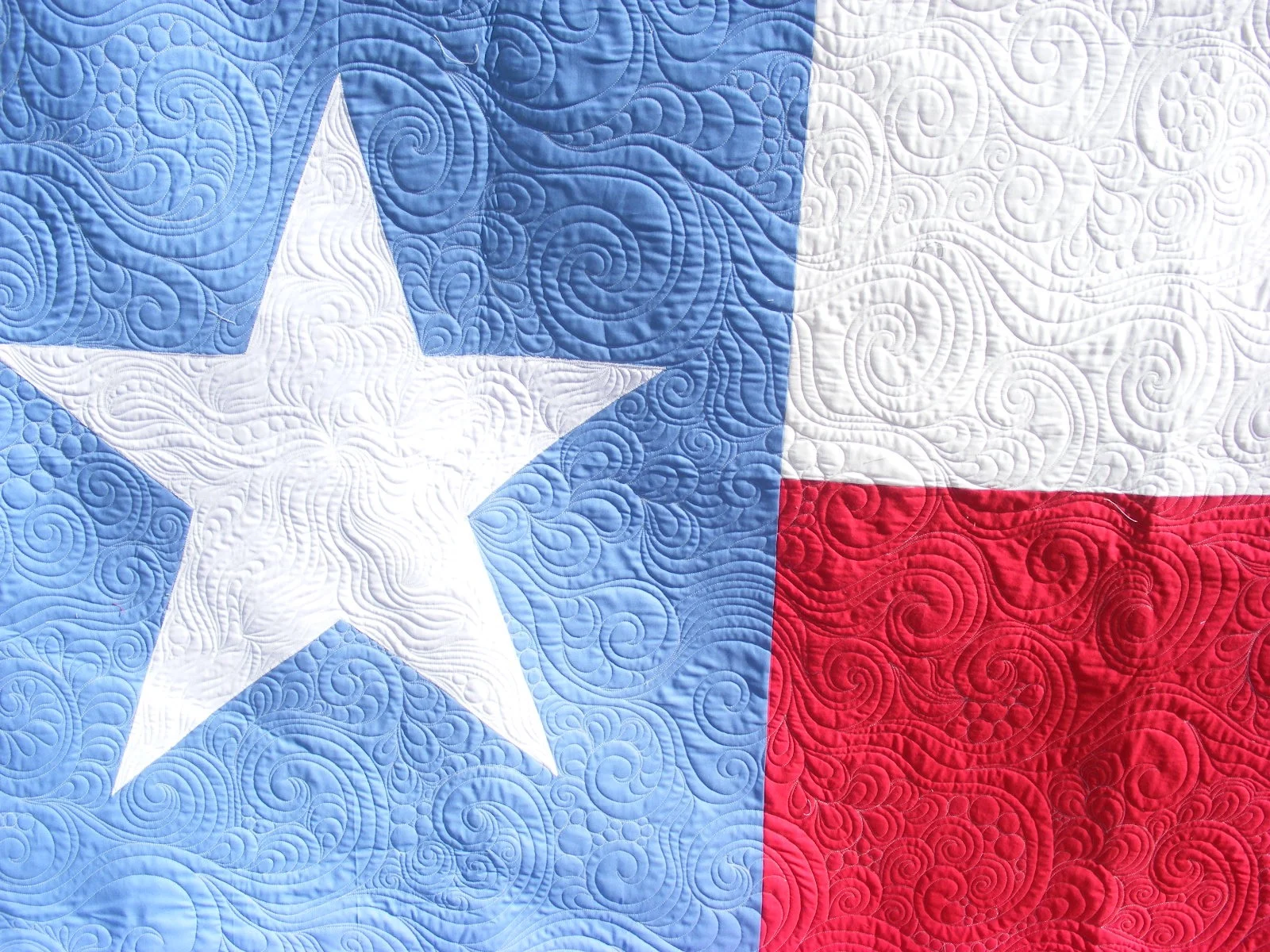 Close-up of the Texas flag quilt with intricate stitching.