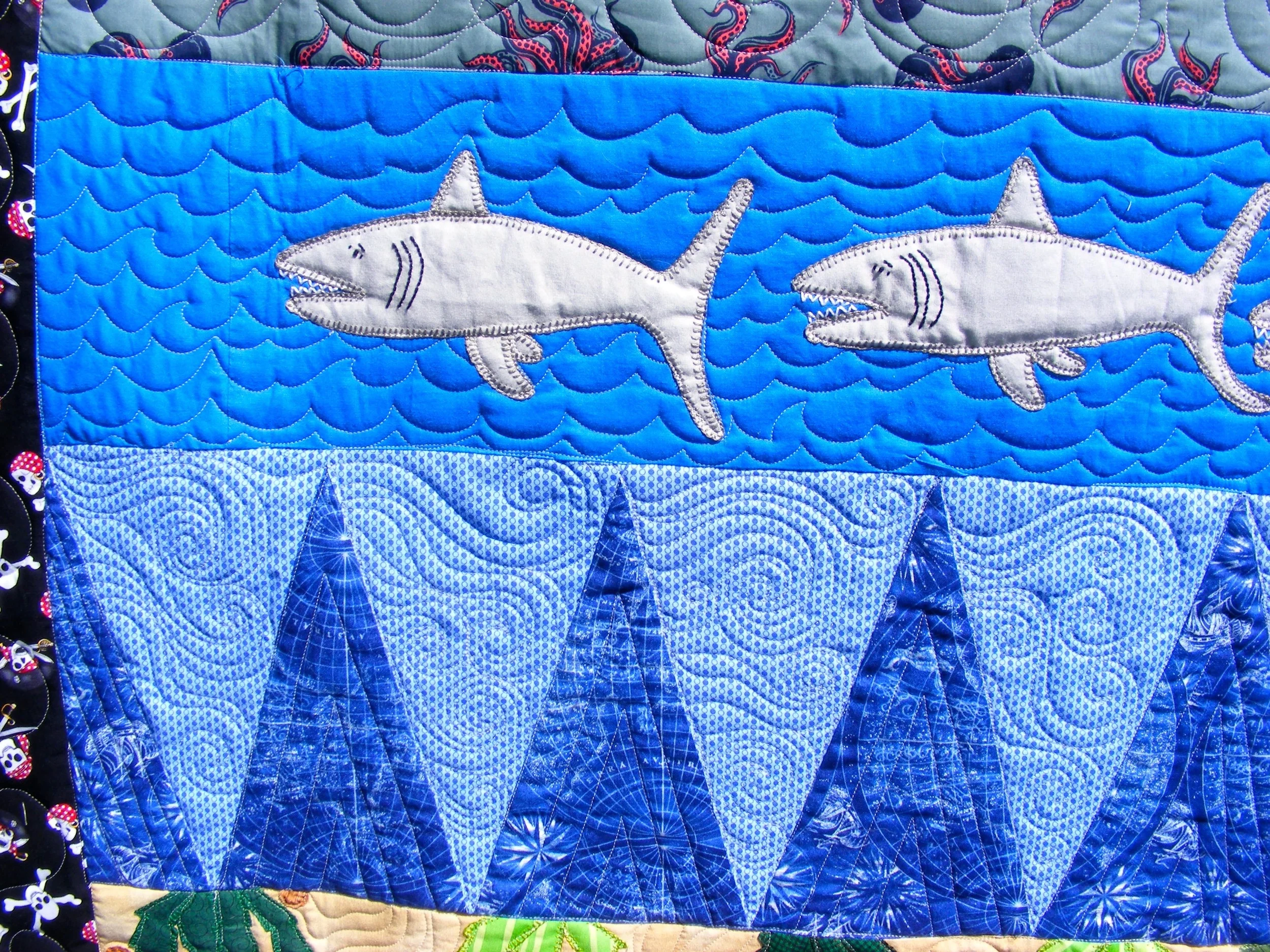 Quilt with shark and wave patterns, featuring blue and gray tones.