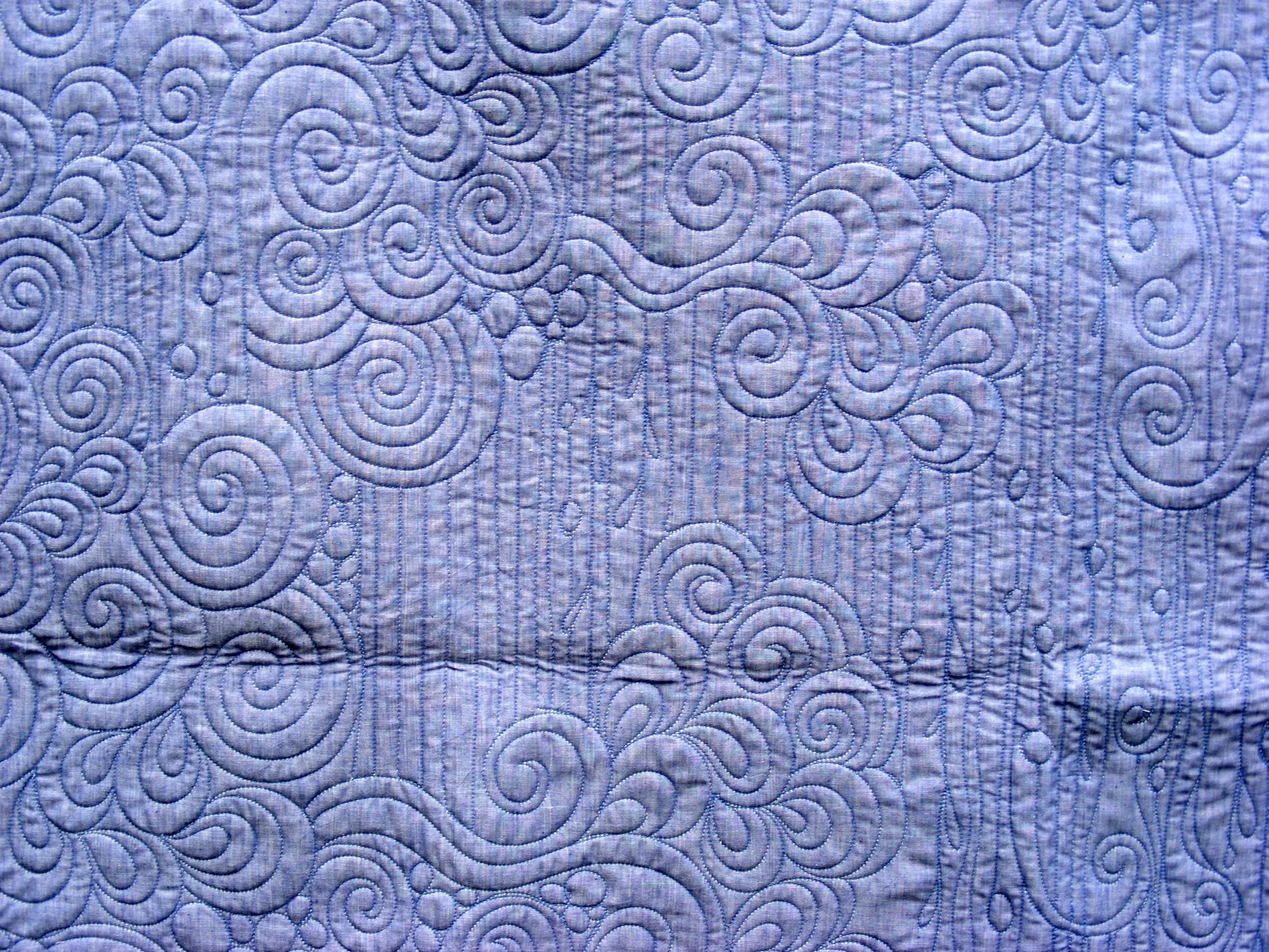 Textured fabric with swirling embroidery pattern