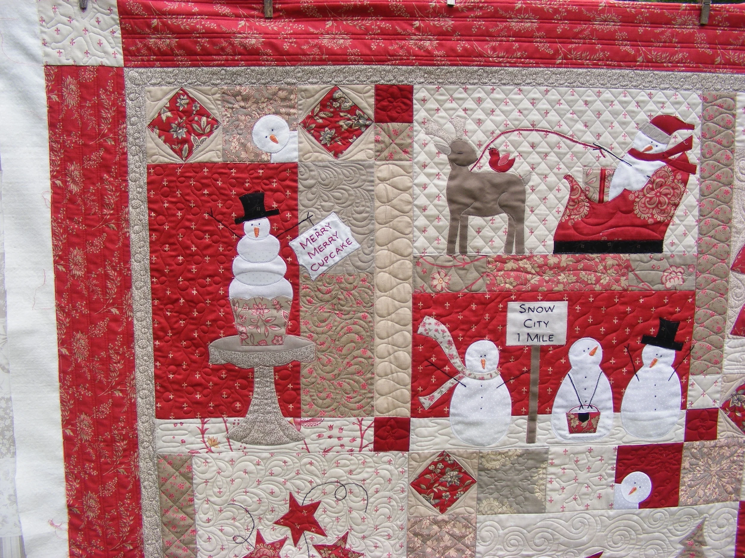 Quilt with snowmen, reindeer, and Santa in red and beige colors