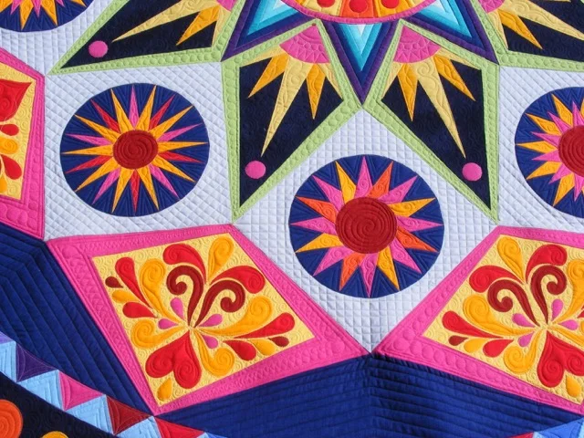Colorful geometric pattern on a quilt with starburst and floral designs