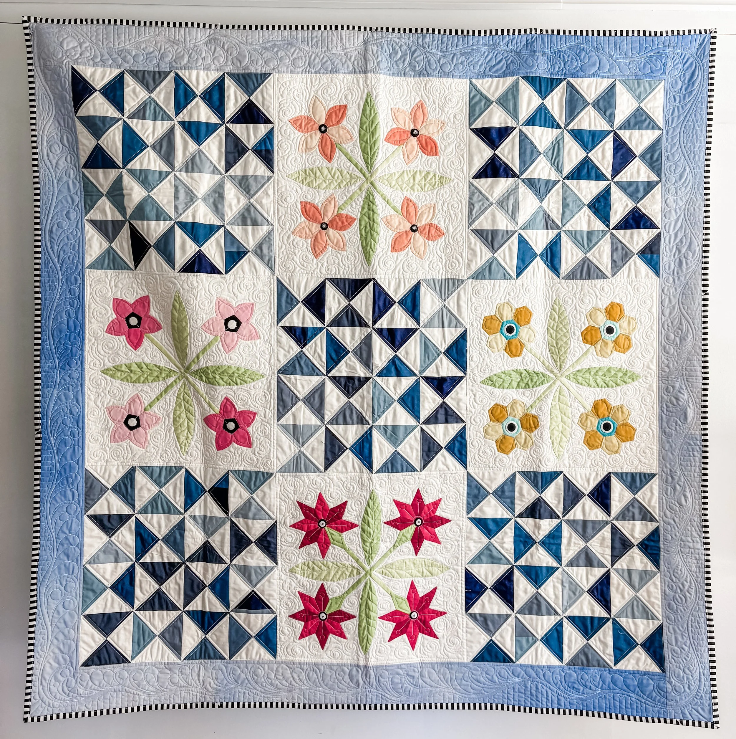 Laura's Garden made by Tia Curtis. I wanted to experiment with english paper piecing. I quickly figured out that I dont have the patience to make an entire quilt with EPP, so I just appliqued the flowers onto backgrounds and made hourglass blocks to 