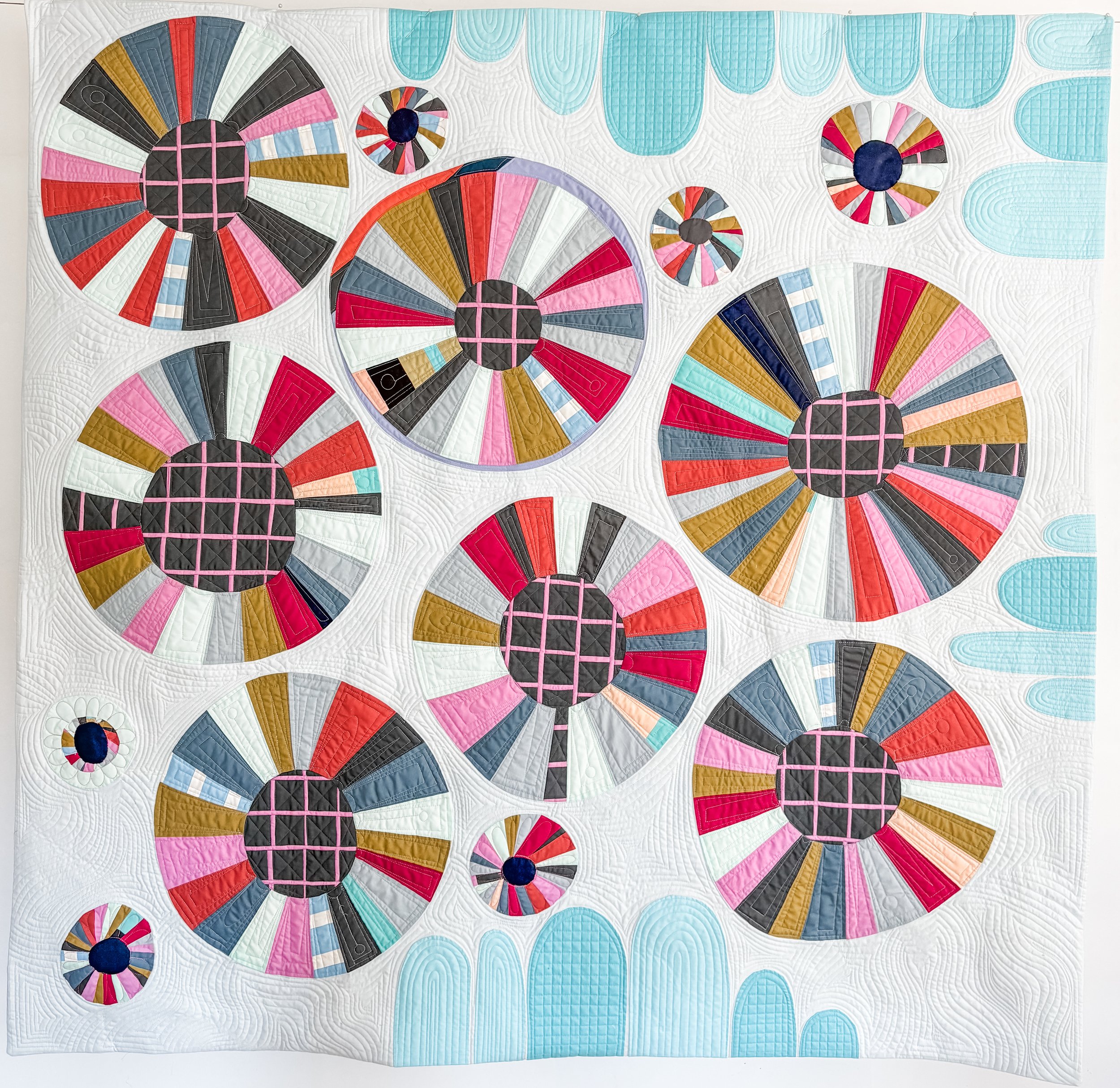 Imposter Syndrome by Tia Curtis. Improv wagon Wheels quilt that unintentionally looks very similar to a work by Tara Faughnan. I custom quilted it on my long arm.
