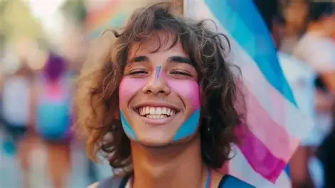 Person smiling with face paint and colorful decorations at an outdoor event.