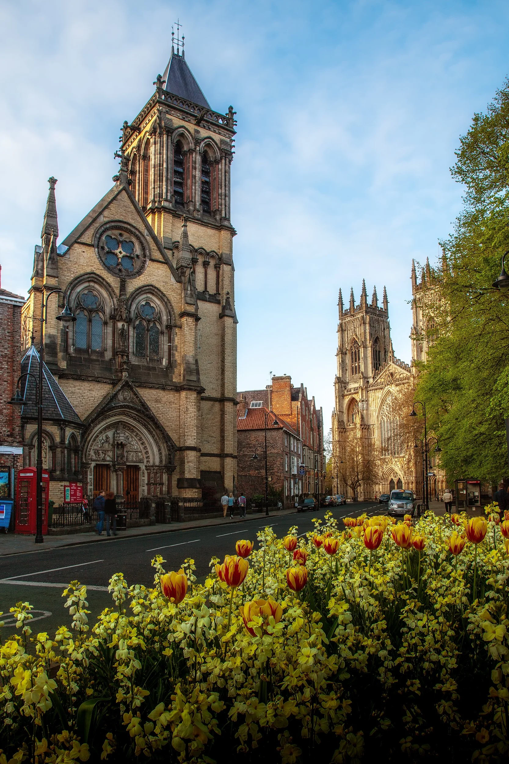 York Street and Minster

 

 This York street scene includes historic church architecture, spring planting, and York Minster visible in the distance. The city center combines medieval streets, religious landmarks, shops, and civic spaces. 