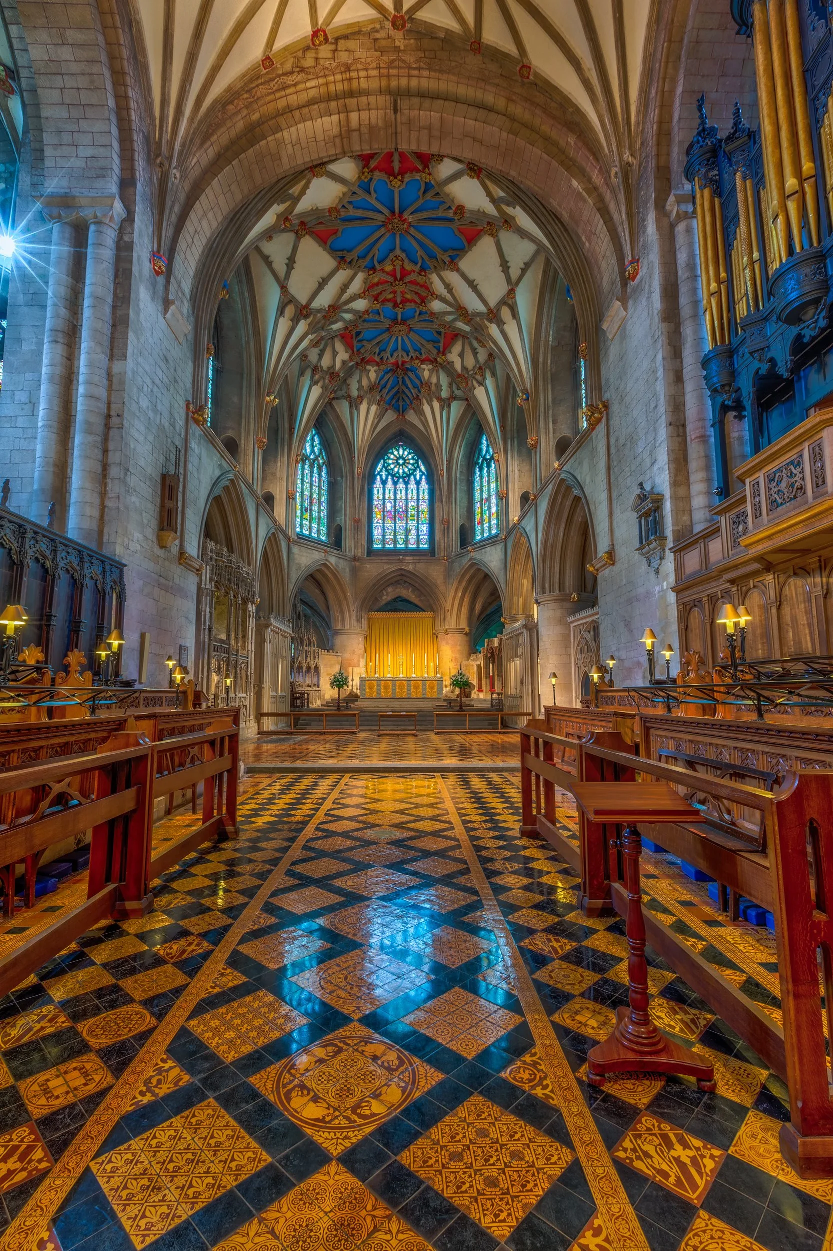 Bath Abbey Nave

 

 Bath Abbey stands in the historic center of Bath, England. This interior view shows the church's stone arches, stained glass, decorative floor, organ case, and vaulted ceiling. 