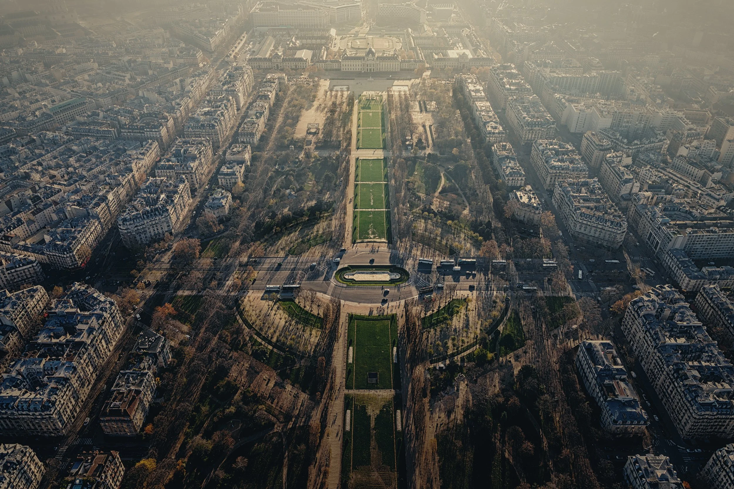 Paris from the Eiffel Tower

 

 This elevated view from the Eiffel Tower looks over the Champ de Mars and surrounding Paris streets. The formal green space extends from the tower toward the Ecole Militaire in the 7th arrondissement. 