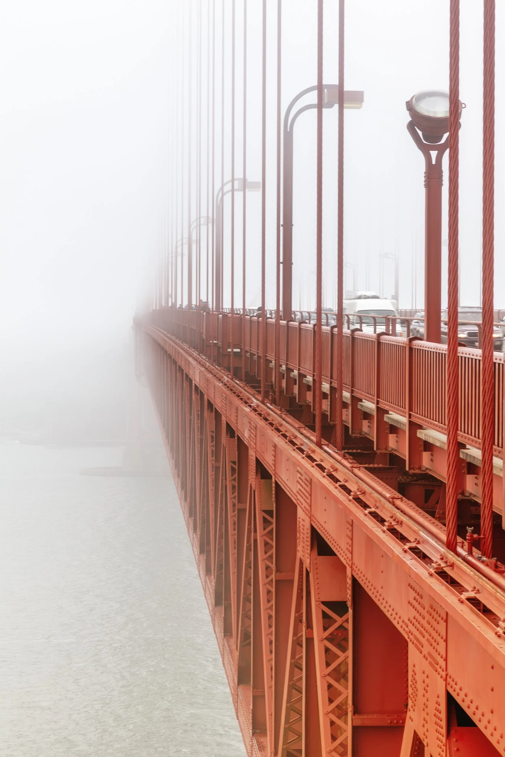 Bridge Walk in Fog

 

 The east sidewalk of the Golden Gate Bridge passes near the North Tower as dense coastal fog softens the bridge structure and bay beyond. 
