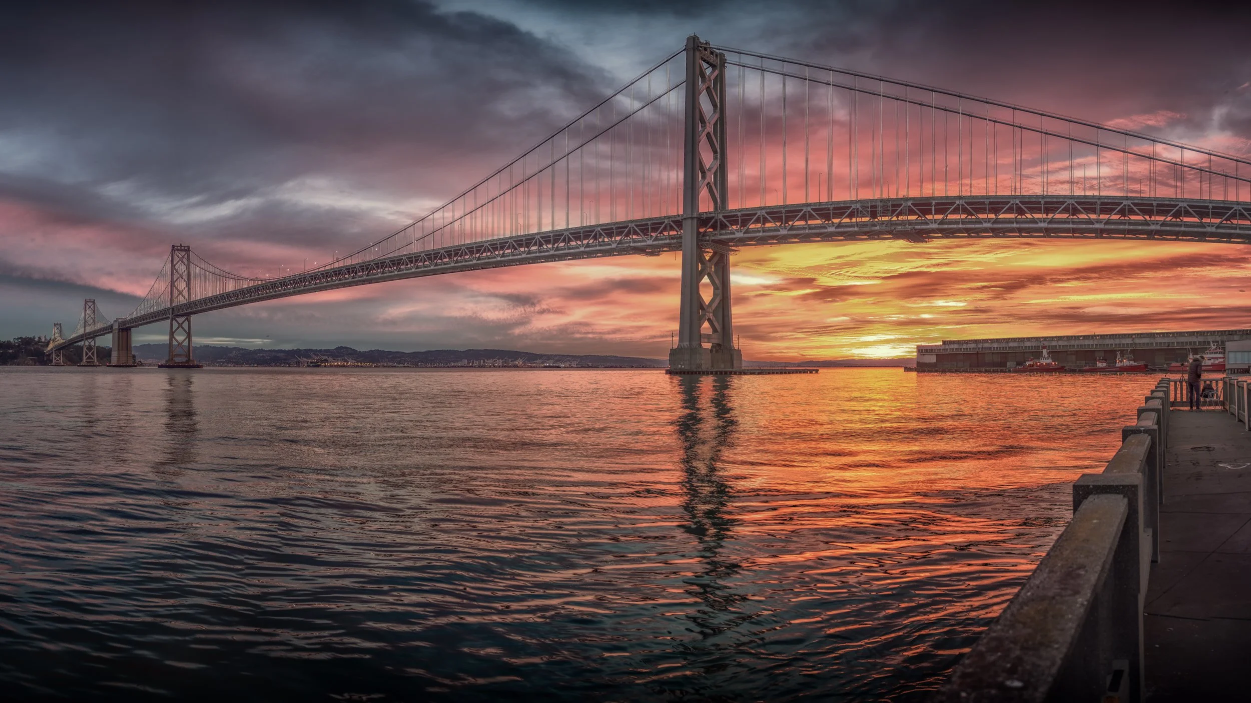 Bay Bridge at Sunset

 

 The western span of the San Francisco-Oakland Bay Bridge crosses the bay near the Embarcadero waterfront. This view was made from near Pier 14, a public pier close to downtown San Francisco. 