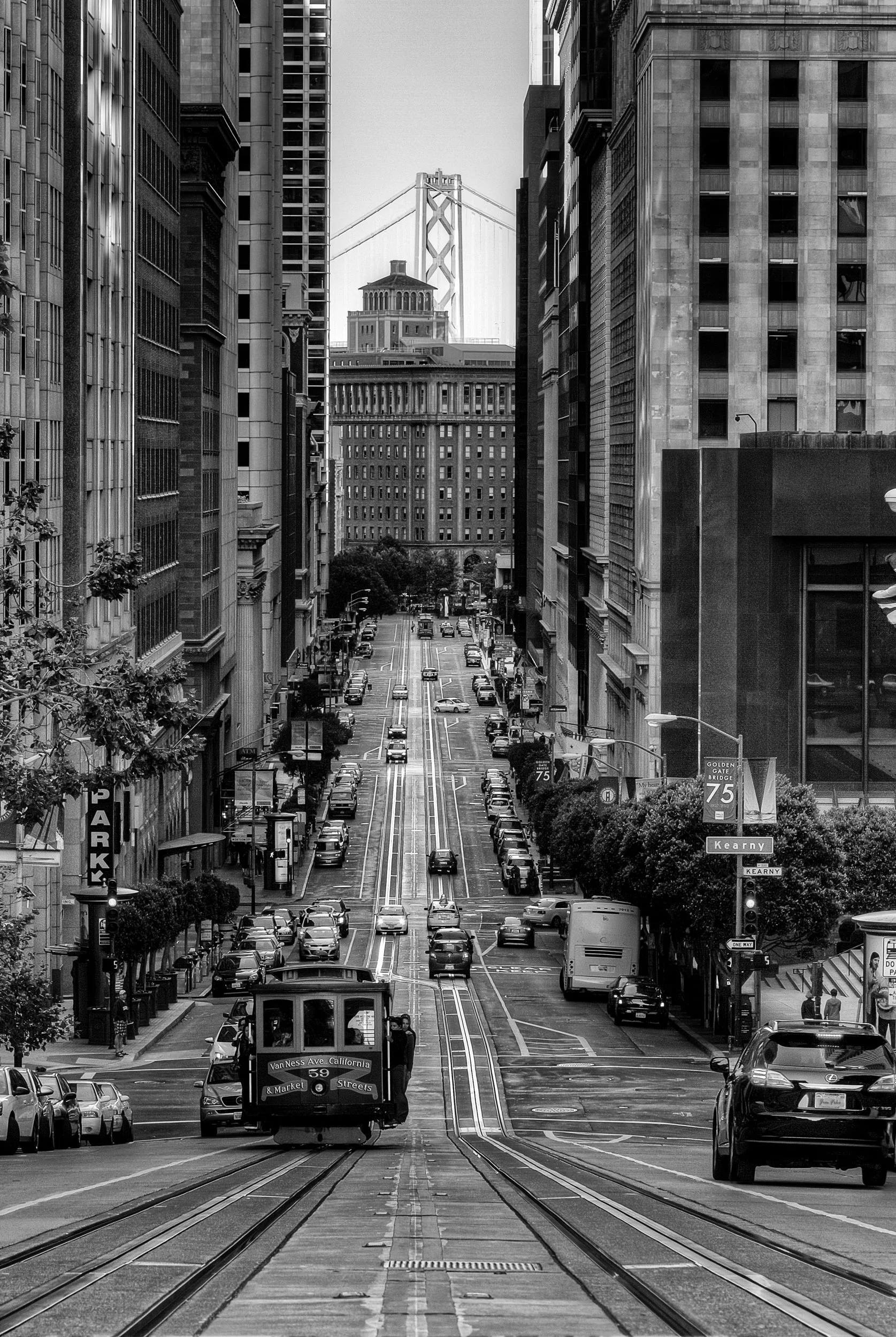 Lines of the City

 

 A cable car moves along California Street at Grant Avenue in San Francisco, with the Bay Bridge visible in the distance. The city’s cable car system remains one of its best-known historic transportation features. 