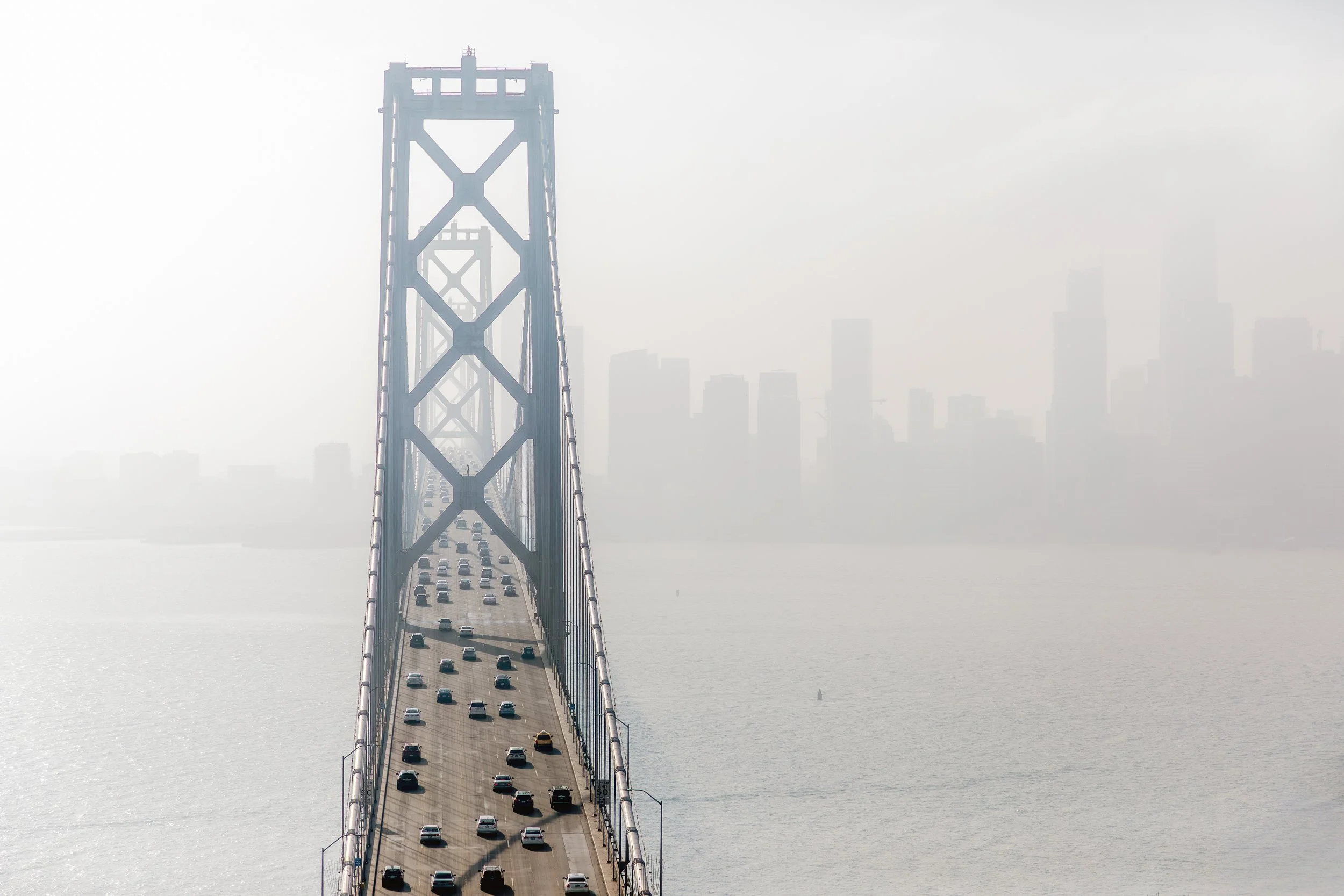 Bay Bridge in Coastal Fog

 

 The San Francisco-Oakland Bay Bridge appears through dense coastal fog while the downtown skyline remains faint in the background. The scene records a familiar Bay Area weather condition around one of California’s major