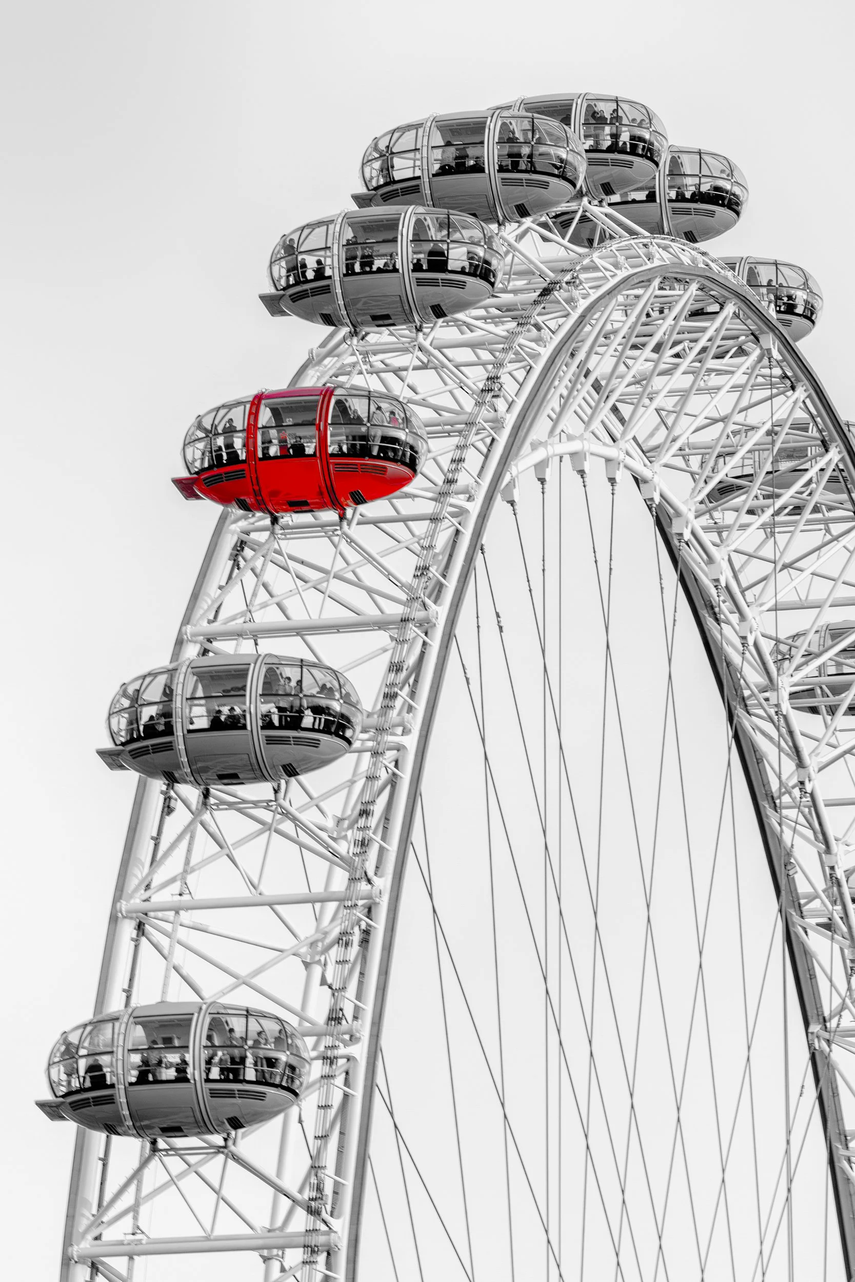 One Among Many

 

 The London Eye rises above the South Bank of the River Thames in London. A single red observation capsule stands apart from the surrounding monochrome structure in this selective color architectural study. 

