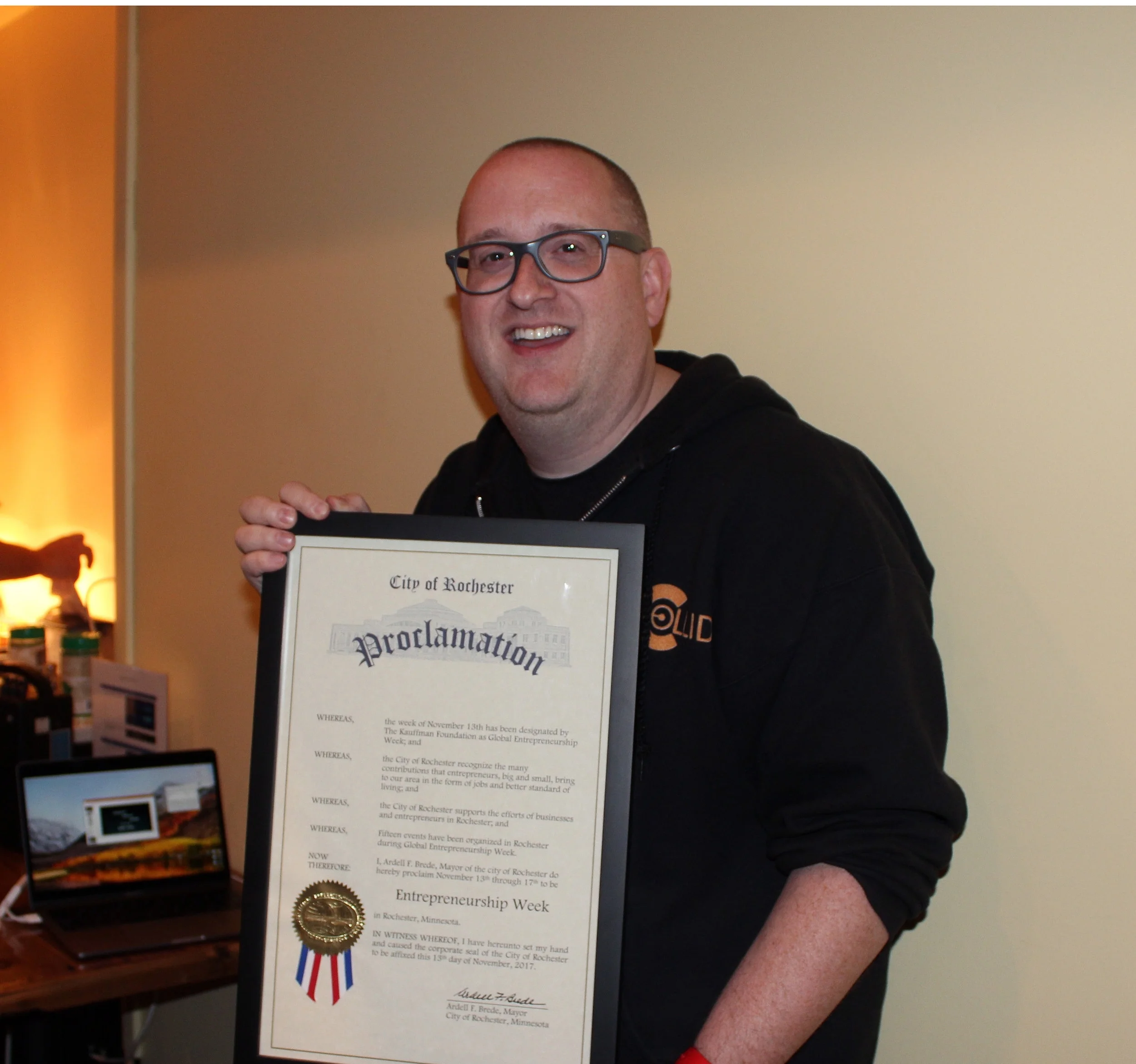 Rochester Global Entrepreneurship Week lead organizer Jamie Sundsbak holding the proclamation from Mayor Brede.
