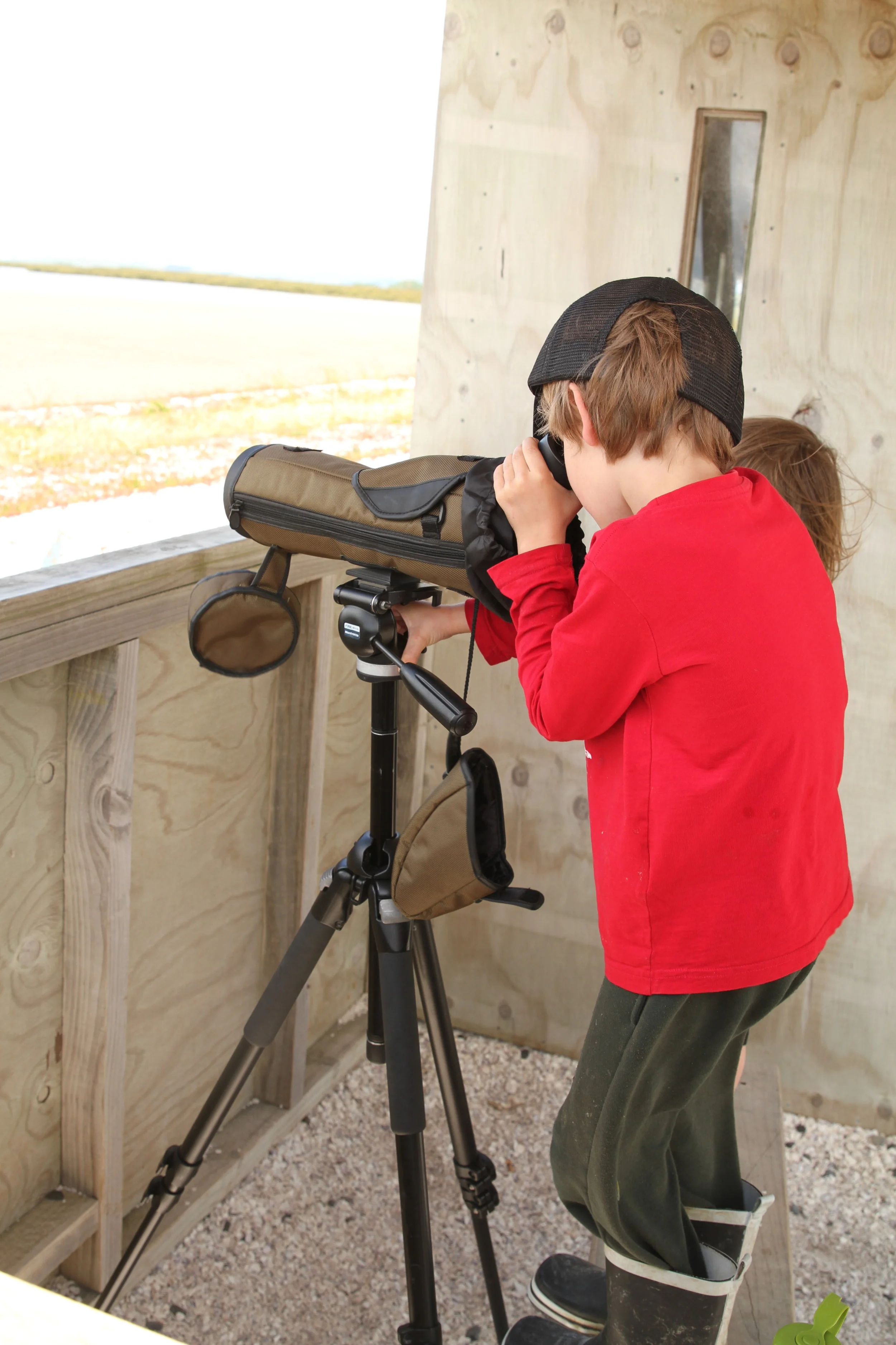 standing on the stool to use the telescope.&nbsp;