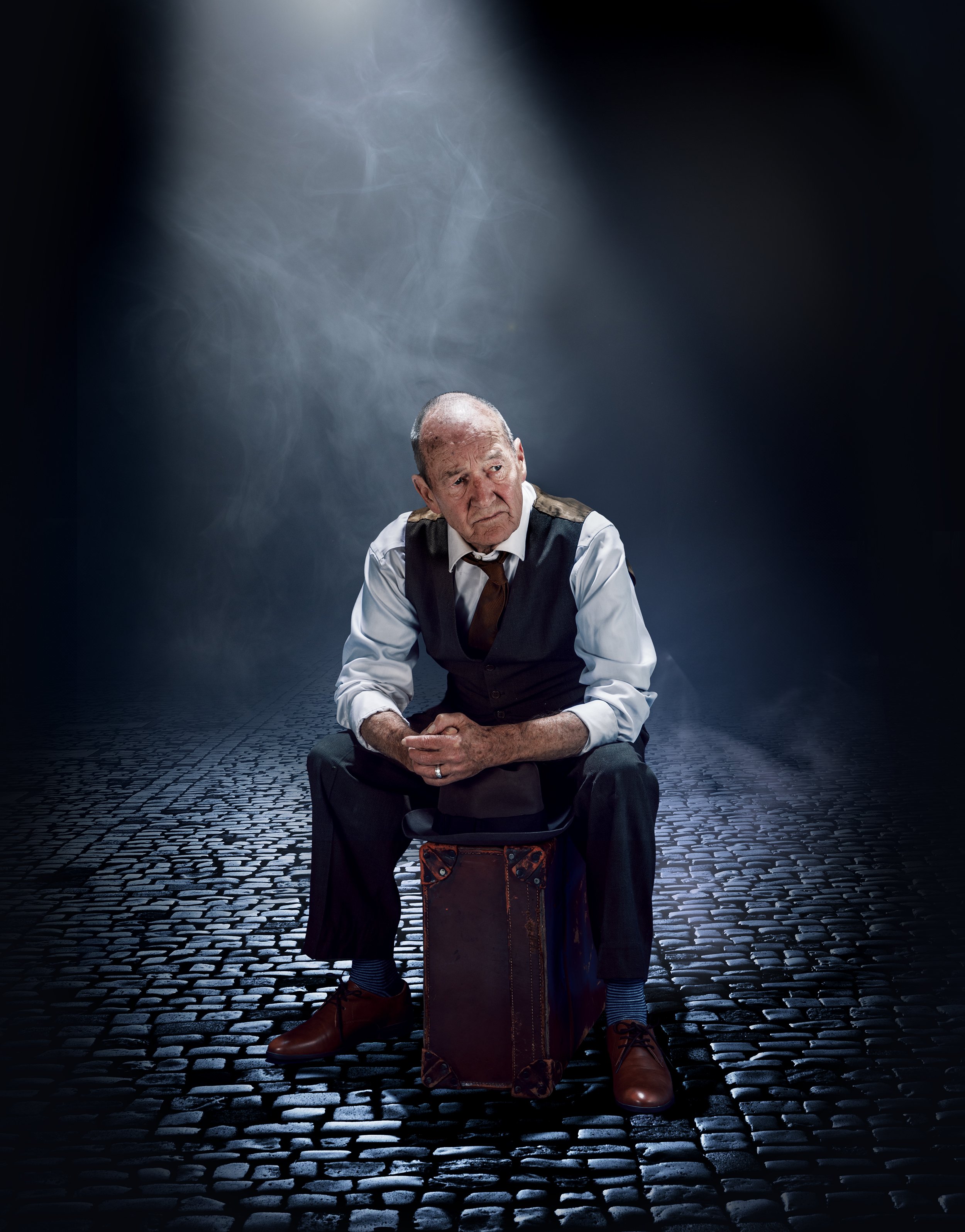 photograph of actor David Hayman sitting on a suitcase to promote Death of a Salesman UK tour 2025