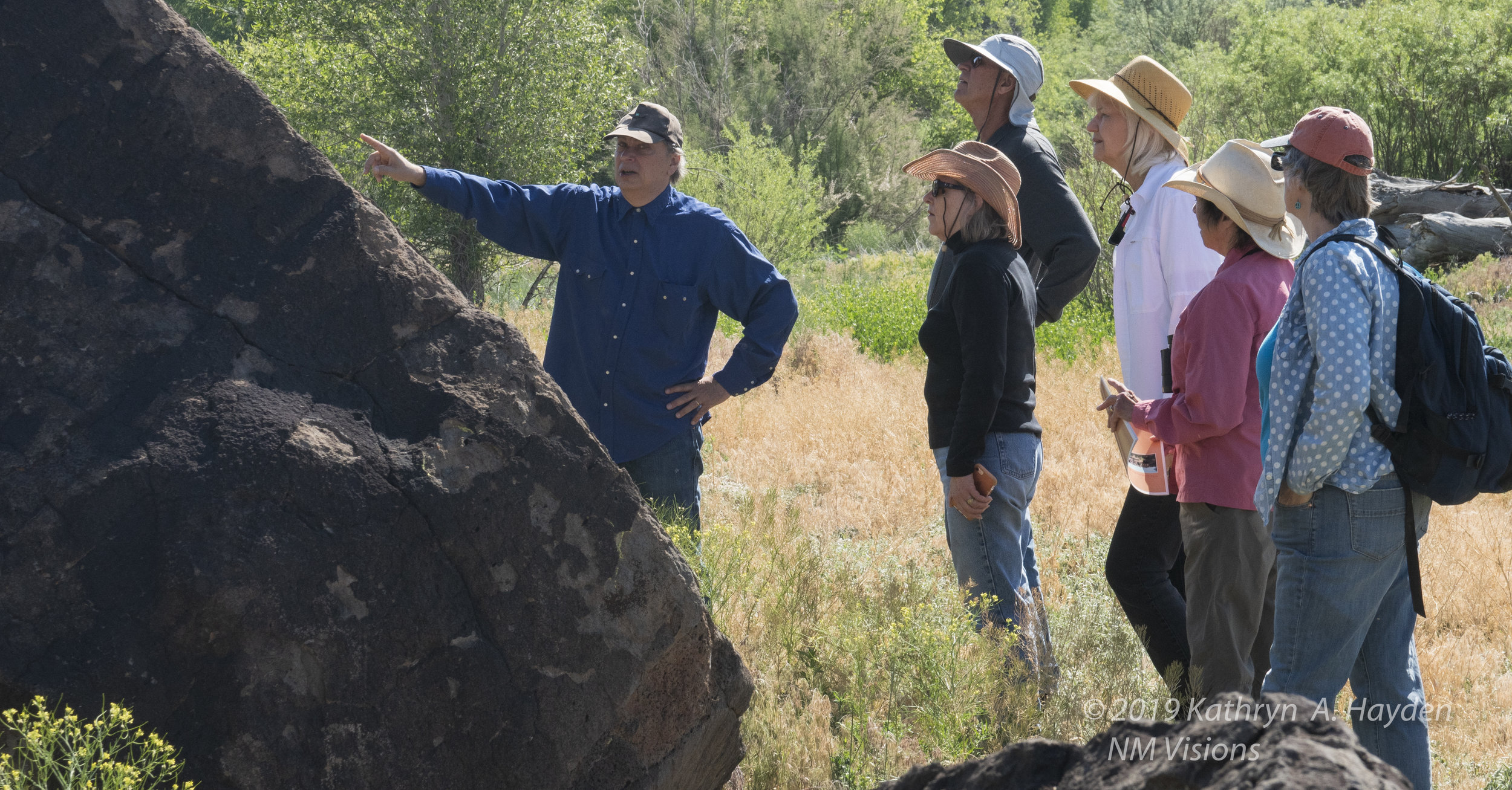  the group listens as Robert points out more petroglyphs and some of the theories about their origins and meanings. 