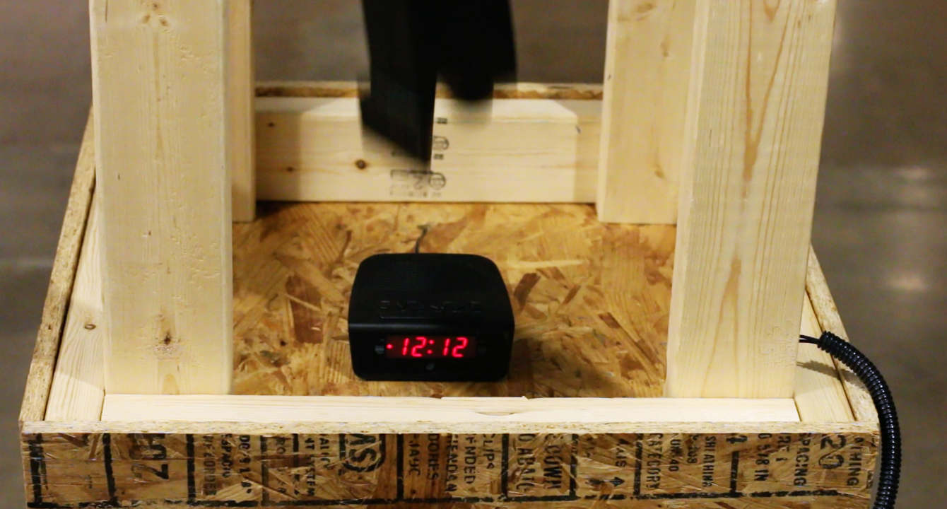 Pressing the red button drops a heavy anvil on the alarm clock, crushing it and, in the process, turning off the alarm.