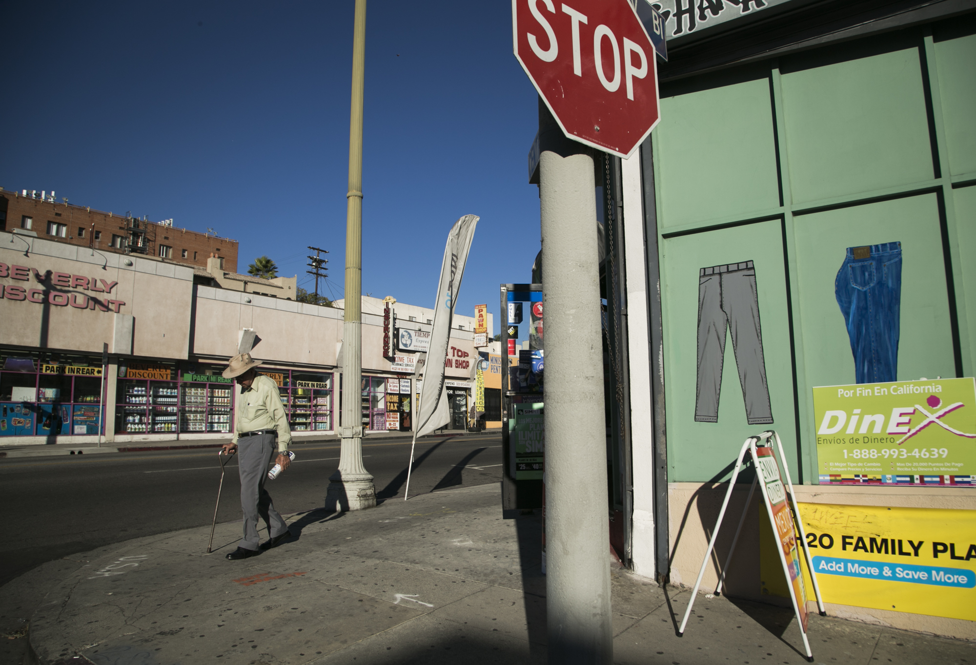 A bystander walks along the corner of Mariposa Street and Beverly Boulevard in Koreatown. The street shows a variety of Salvadorian owned businesses that cater to the Spanish speaking community including remittance services, a mobile store that provides pre-paid phone cards and an El Salvadorian market. The 1980s marked Koreatown’s dramatic transformation to becoming a multicultural space. During this period, a large influx of Central Americans, Mexican Americans and Bengali Americans began to move in to the area.
