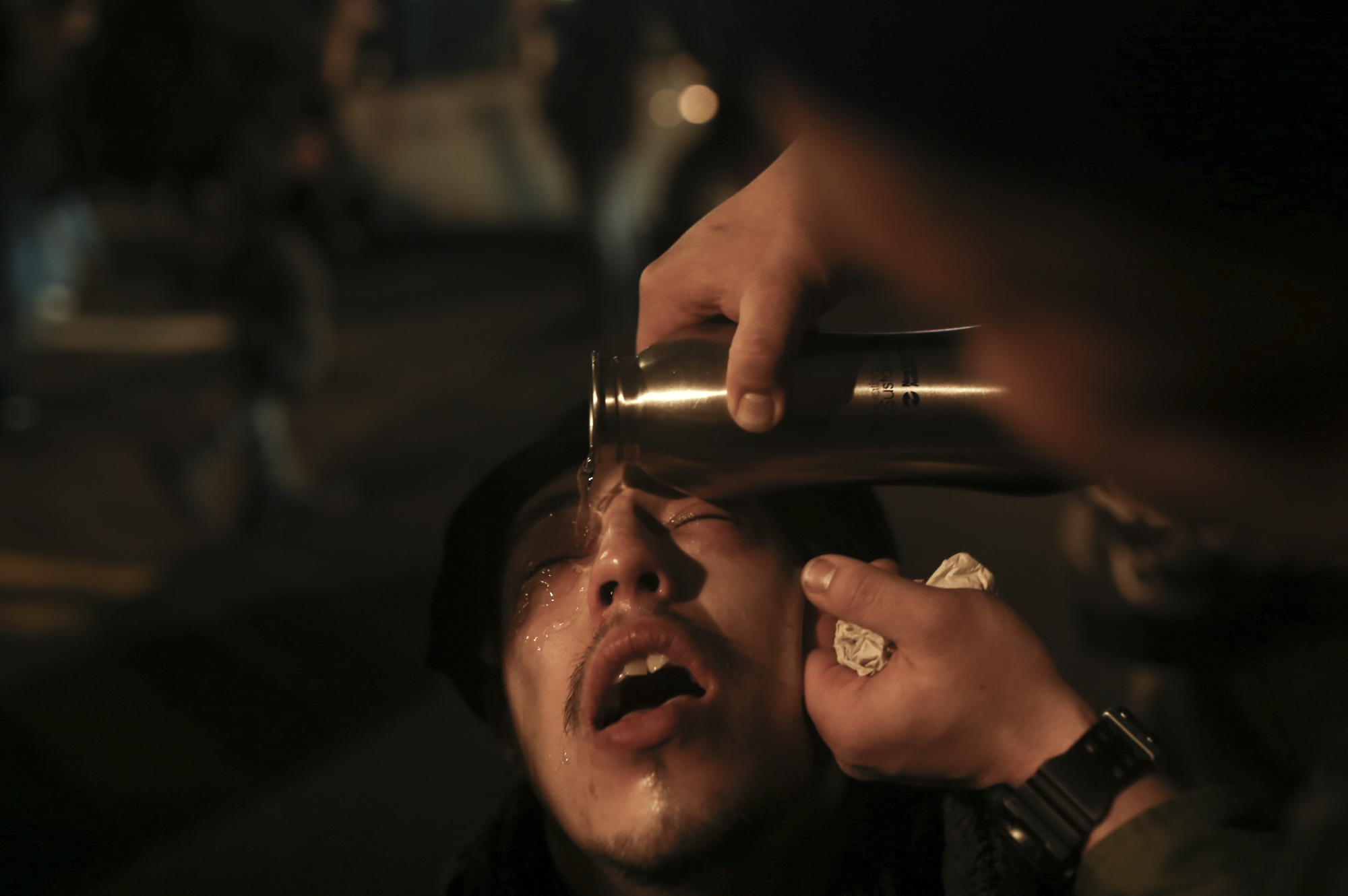  A protestor reacts as a friend &nbsp;rinses his eyes. Riot officers used pepper spray on protestors on 11th Street and M Street in downtown Washington D.C. following President Donald Trump's inauguration on January 20, 2017 