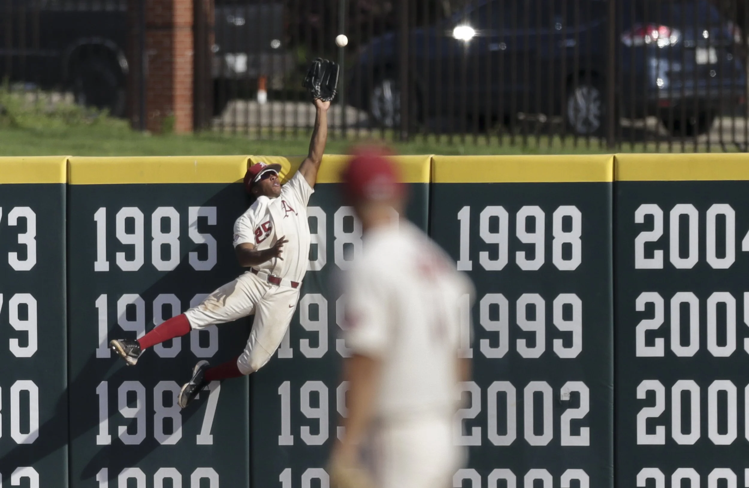 Arkansas outfielder Christian Franklin (25) reaches for a homerun, Sunday, June 13, 2021 during the third inning in Game 3 of the Fayetteville Super Regional at Baum-Walker Stadium in Fayetteville.