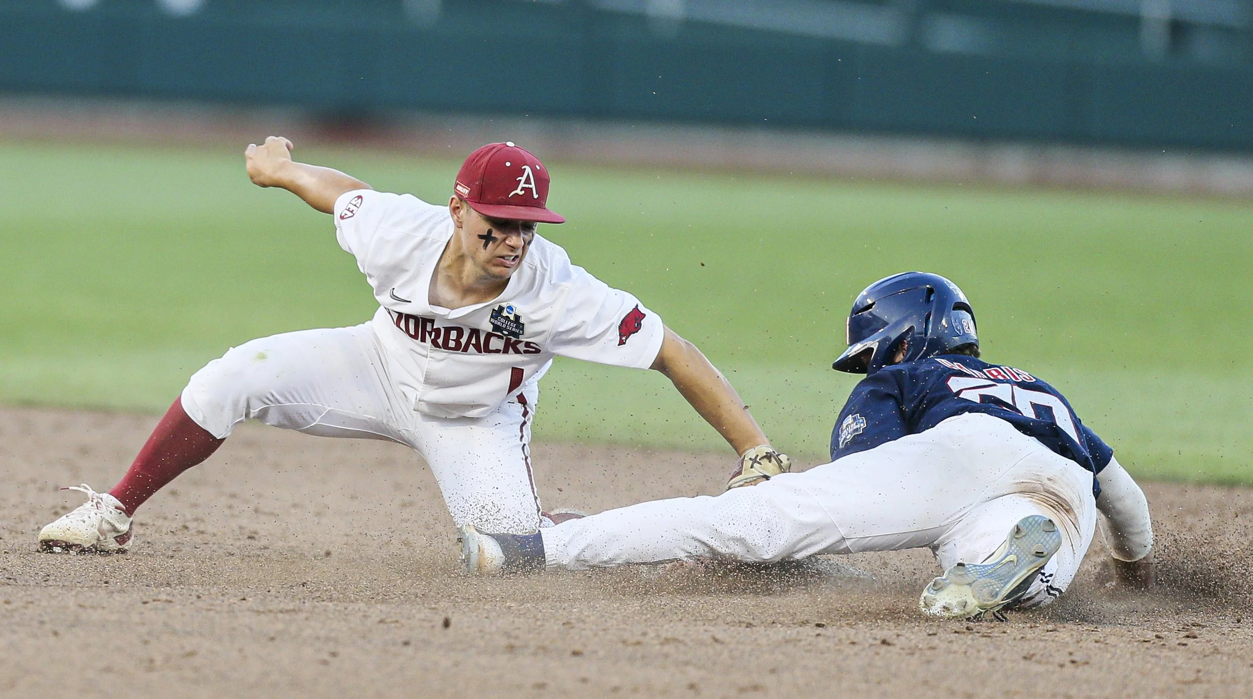 Arkansas infielder Robert Moore (1) attempts to tag Ole Miss Calvin Harris (20) at second, Monday, June 20, 2022 during the sixth inning of a NCAA College World Series double elimination game at Charles Schwab Field in Omaha, Neb.