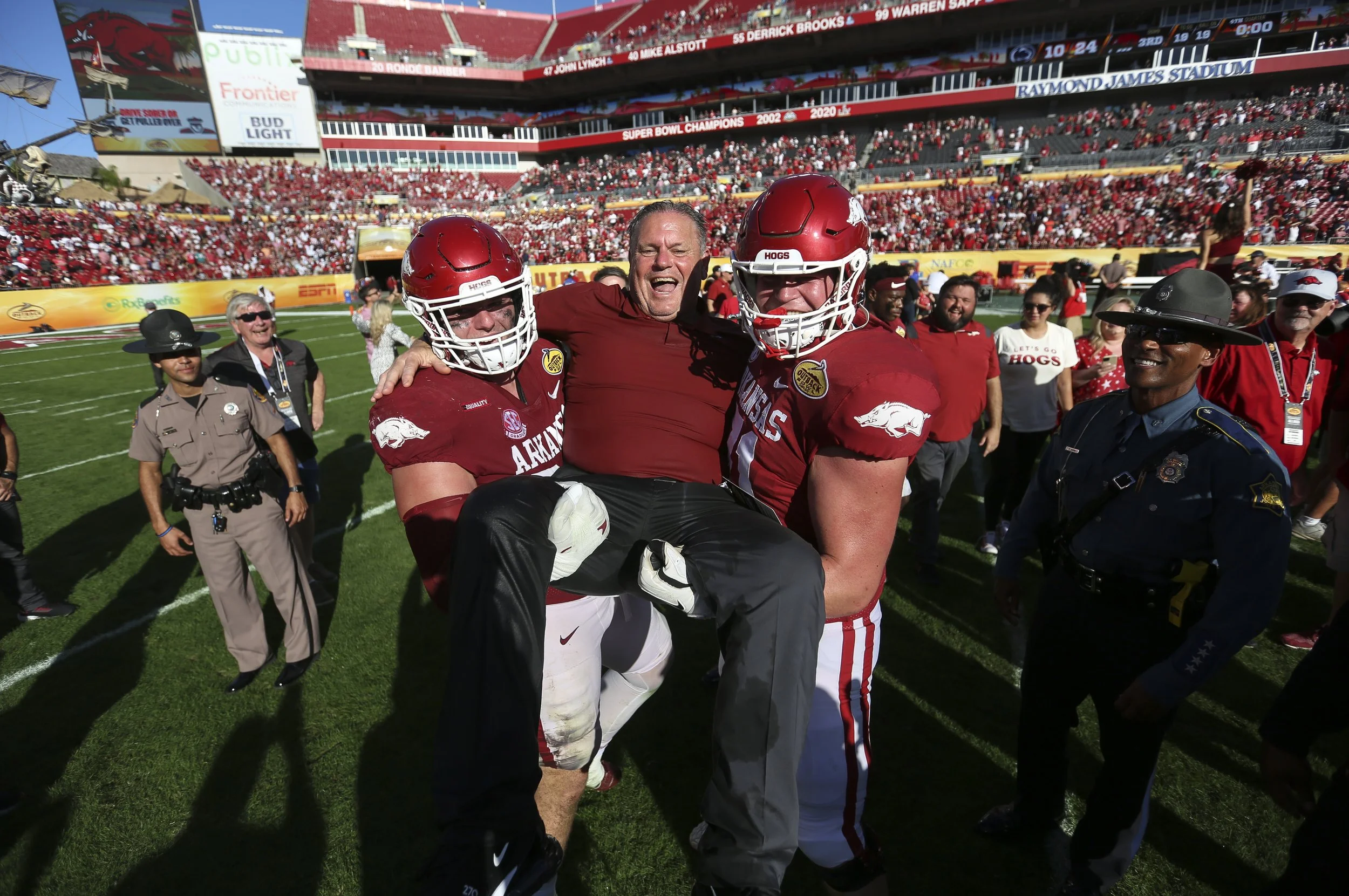 Arkansas defensive lineman John Ridgeway (99) and offensive lineman Ryan Winkel (71) lift head coach Sam Pittman, Saturday, January 1, 2021 after Arkansas' 24-10 win in the Outback Bowl at Raymond James Stadium in Tampa, Fla.