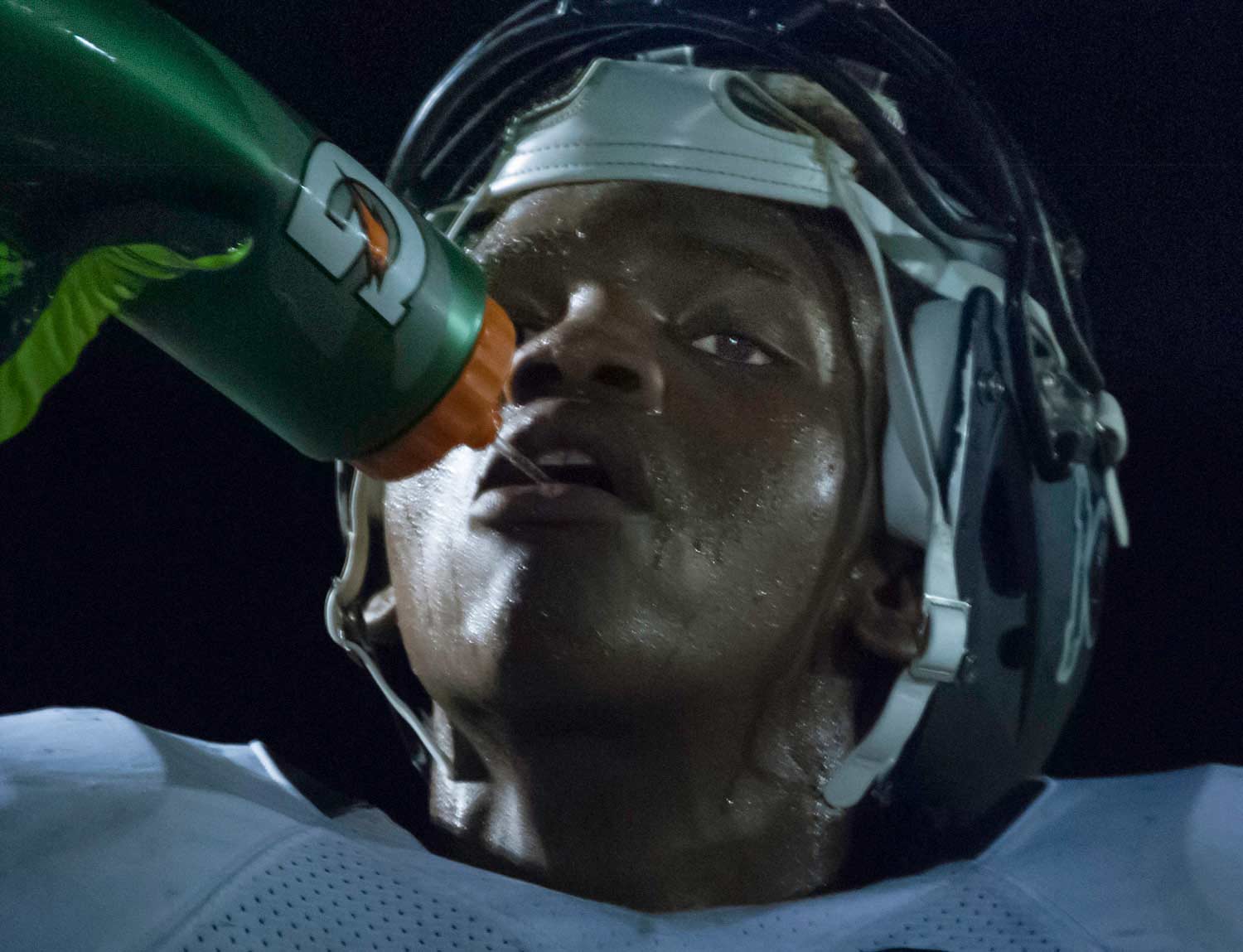 high school football player taking a drink