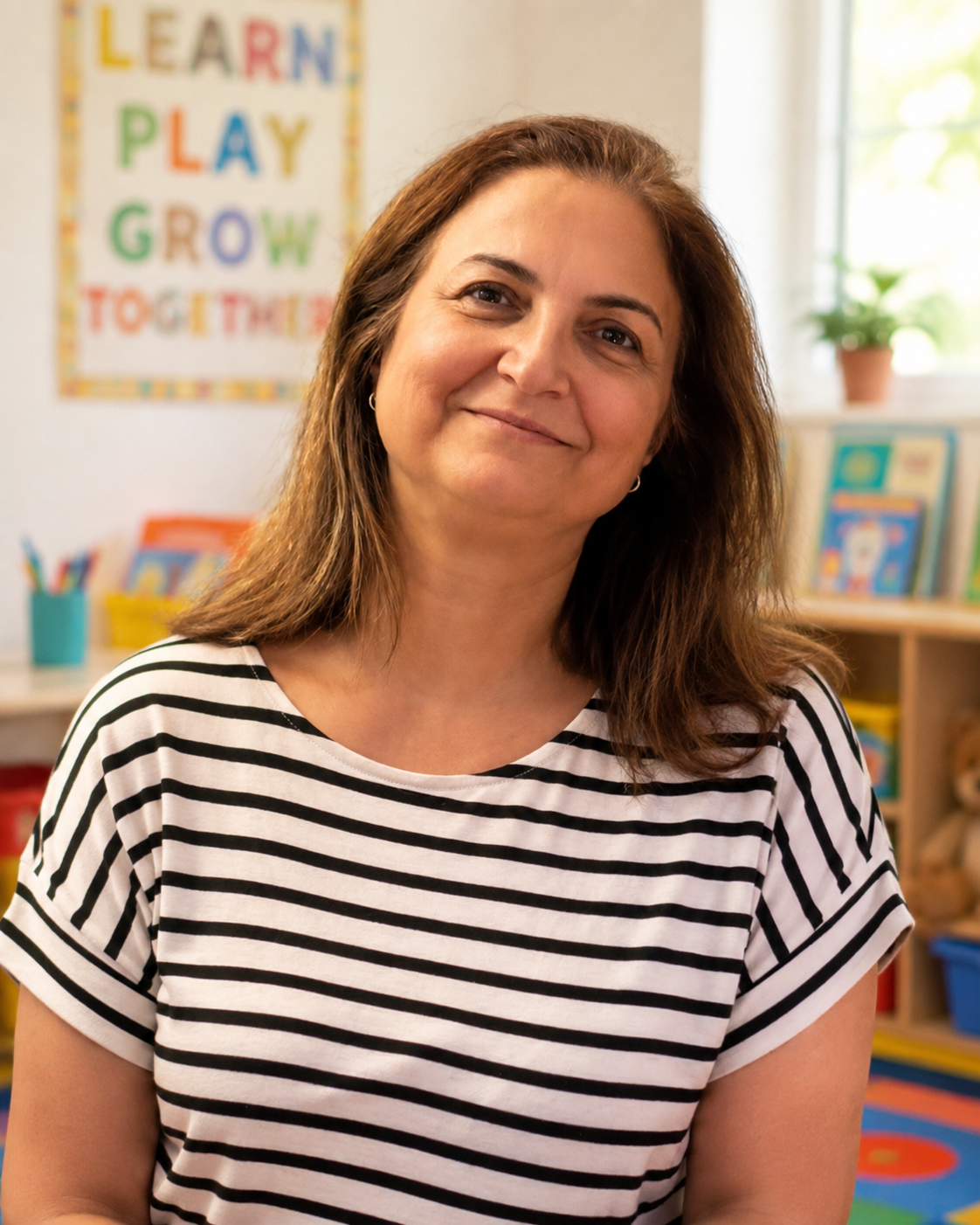 Nazila, lead teacher at Busy Bees Childcare in Lynnwood, WA, smiling in the classroom