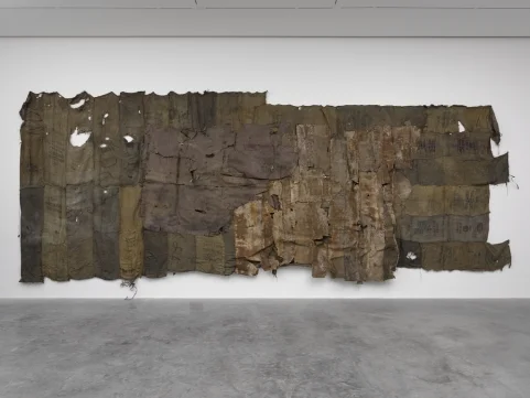 Ibrahim Mahama, Gemtun Boxe , 2016, Old interior leather of scraped Henschel train on charcoal sacks. 177 3/16 x 440 9/16 in. (450 x 1119 cm). Photo: White Cube (George Darrell)