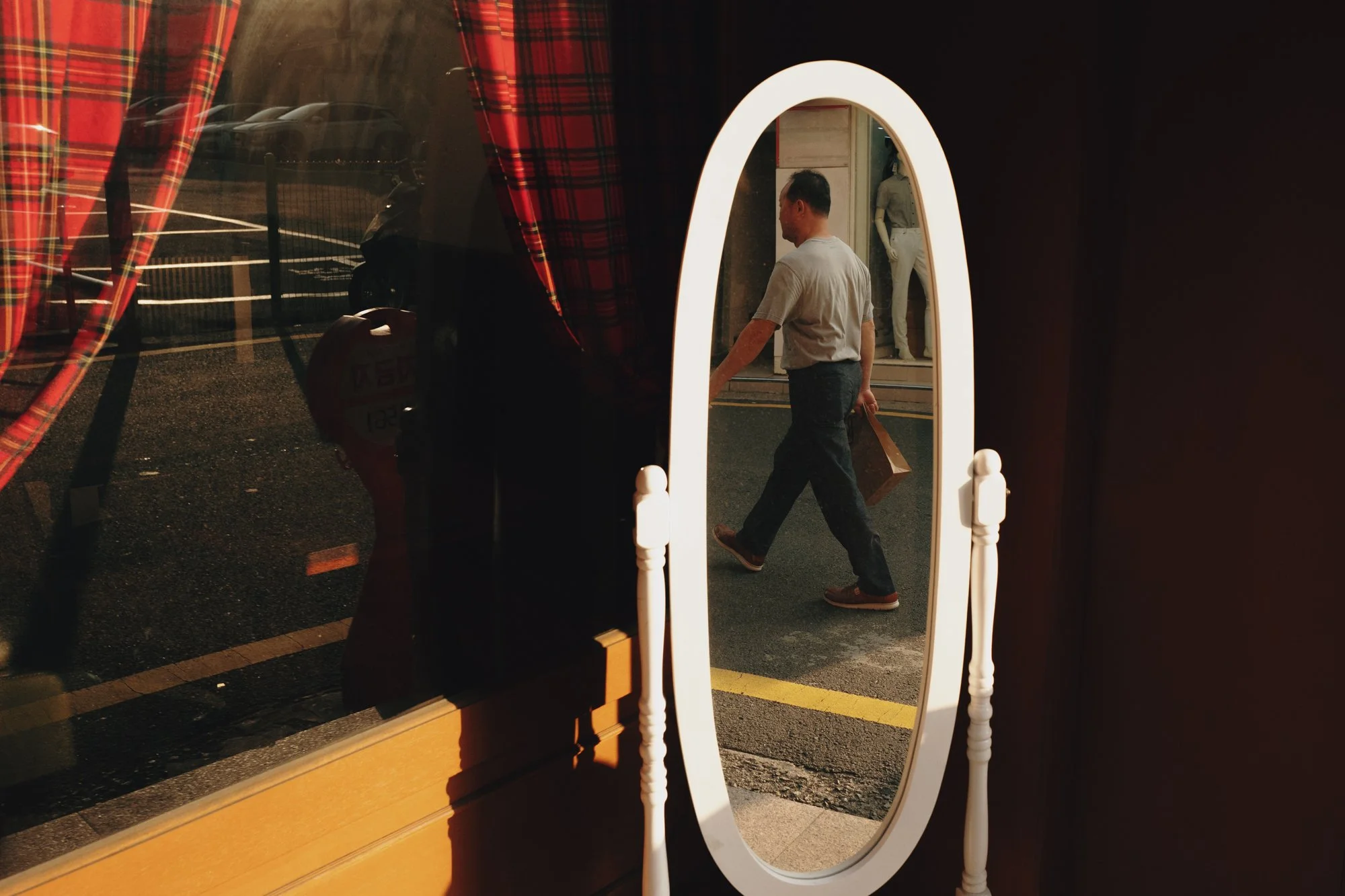 Man enters mirror reflection in Seoul, South Korea.