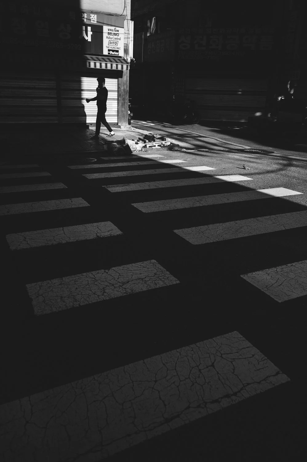 A man walking into a shaft of light in Seoul, South Korea.