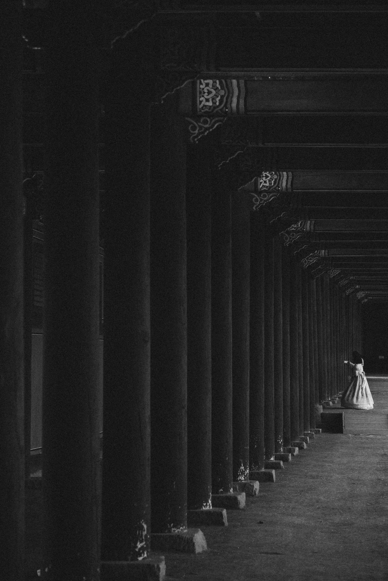 A wooman wearing a Hanbok in Gyeongbokgung palace grounds in Seoul, South Korea.