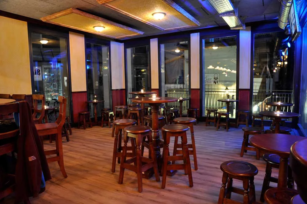 Peggy O'Neils's Irish bar design - interior seating with high wooden tables and stools