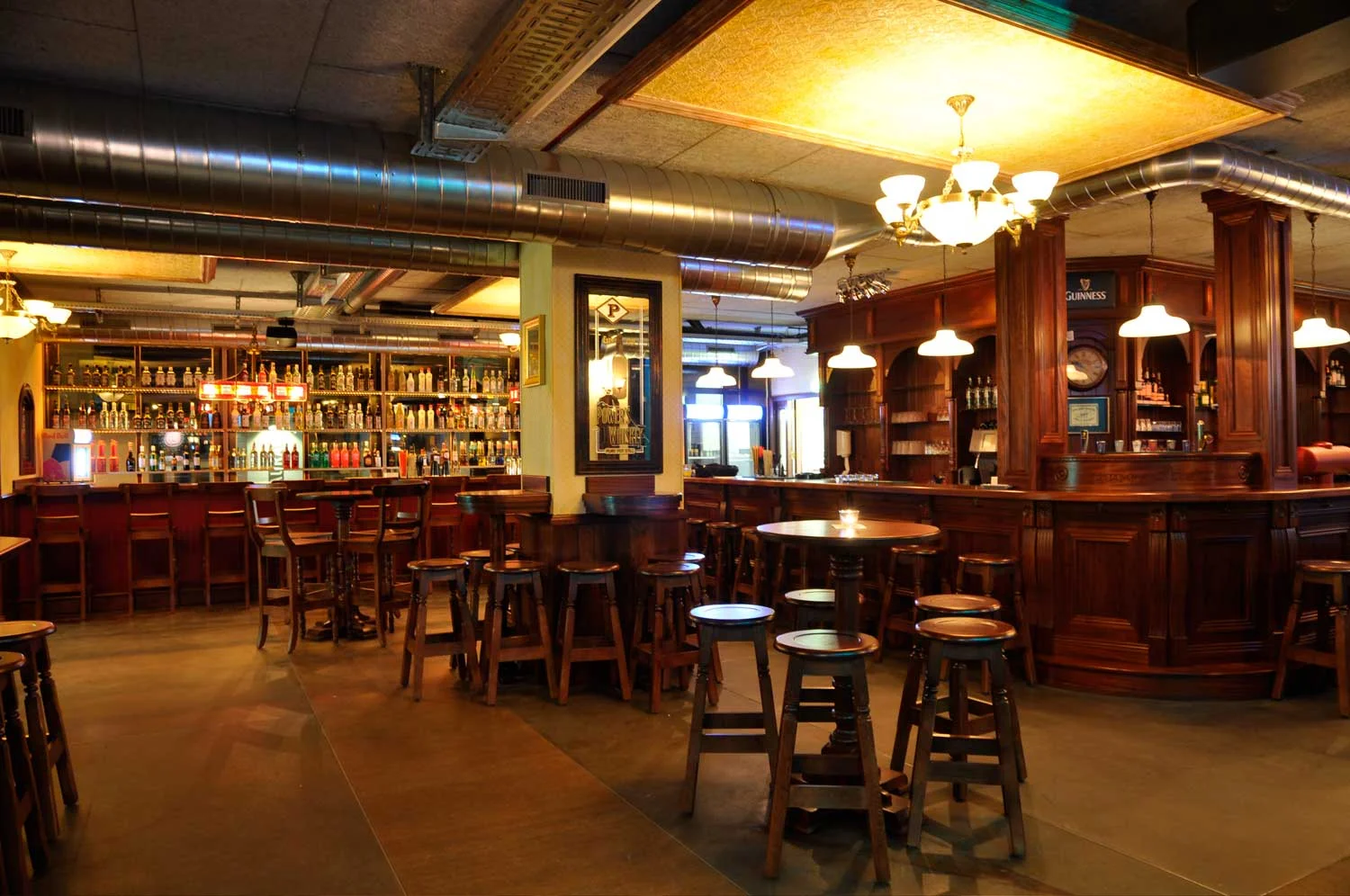 Peggy O'Neil's authentic Irish pub design - interior seating with high wooden tables and stools&nbsp;