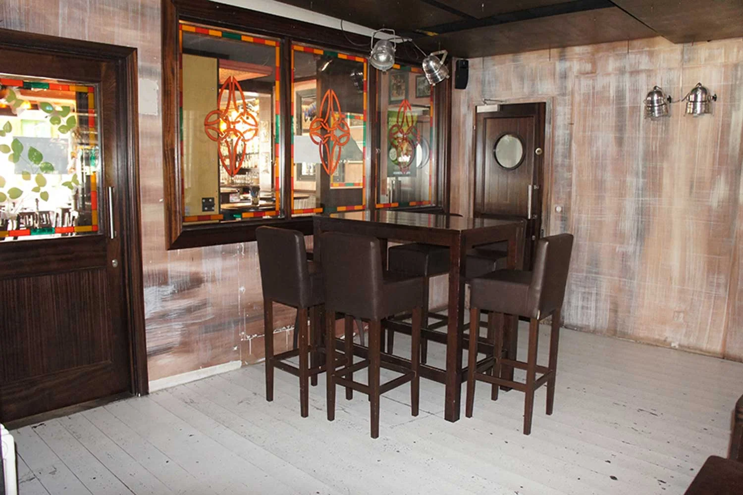  Duffy O'Toole's authentic Irish pub design - interior view of pub corner with high table and stools. Mirrors adorned with celtic emblems.