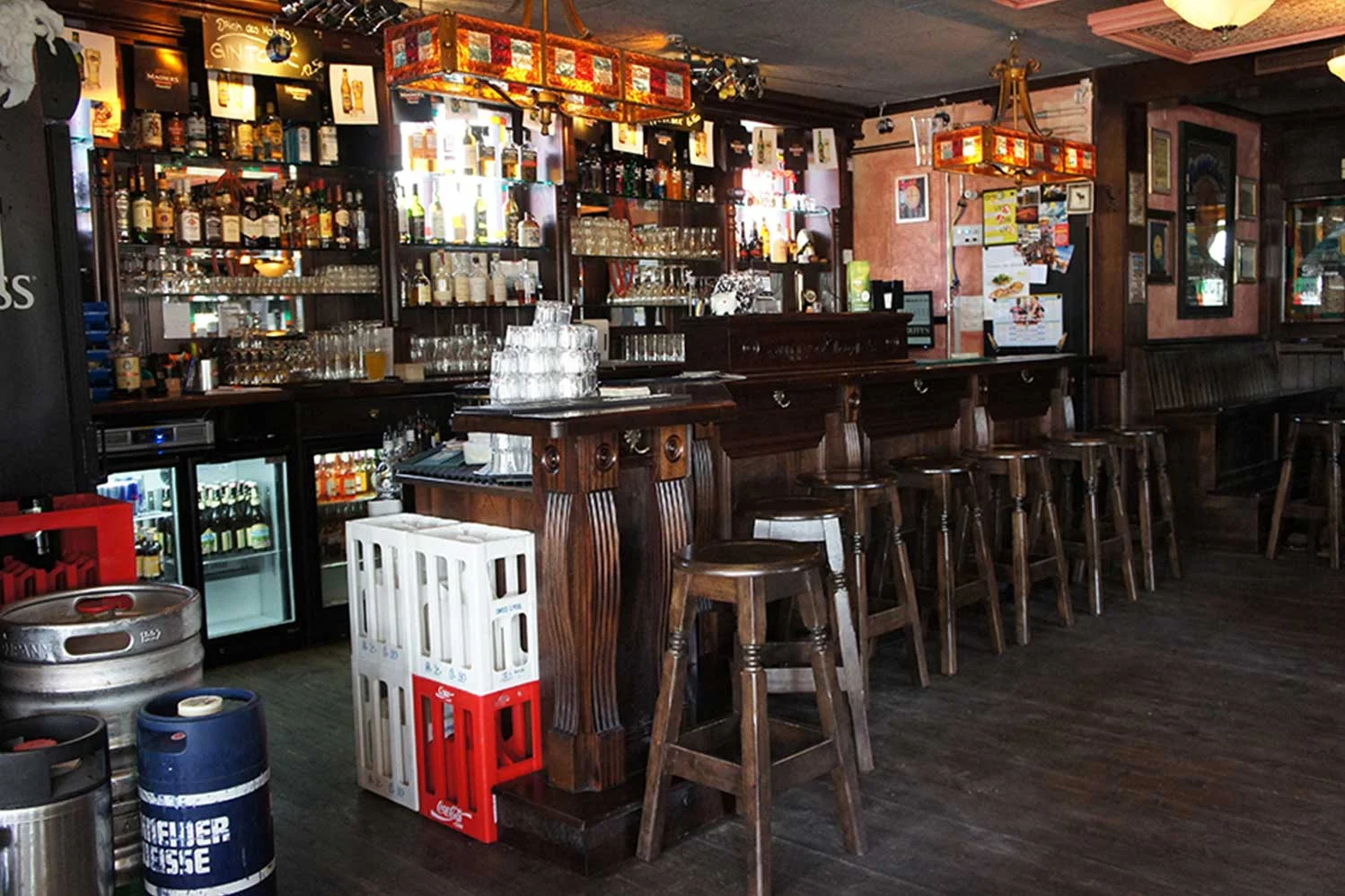 Duffy O'Toole's Irish pub design - interior view of dark wood bar, plastic pallets and kegs piled up at bar.