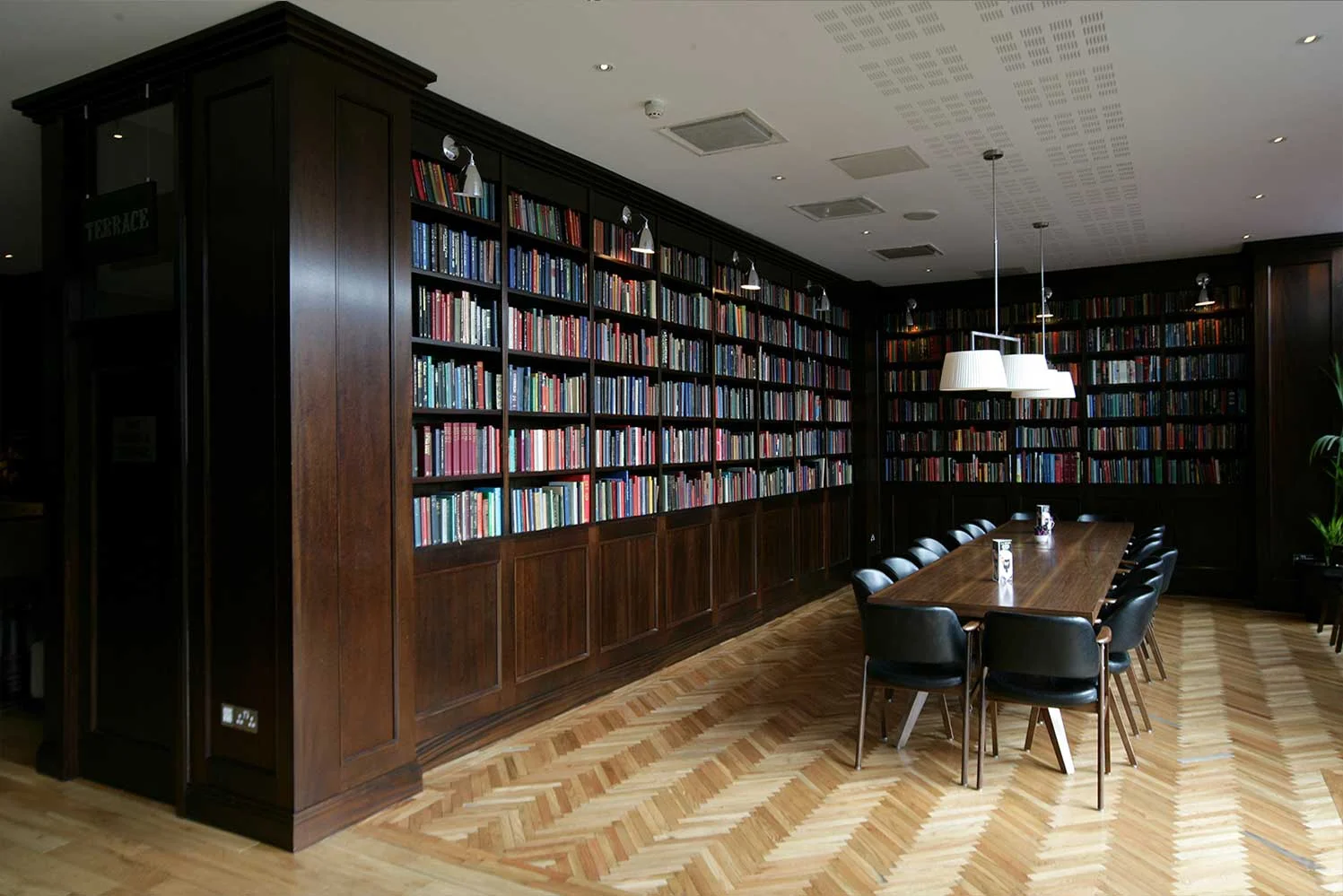 Bewley's hotel bar design - interior dining room with dark wood bookcase and long dining table&nbsp;