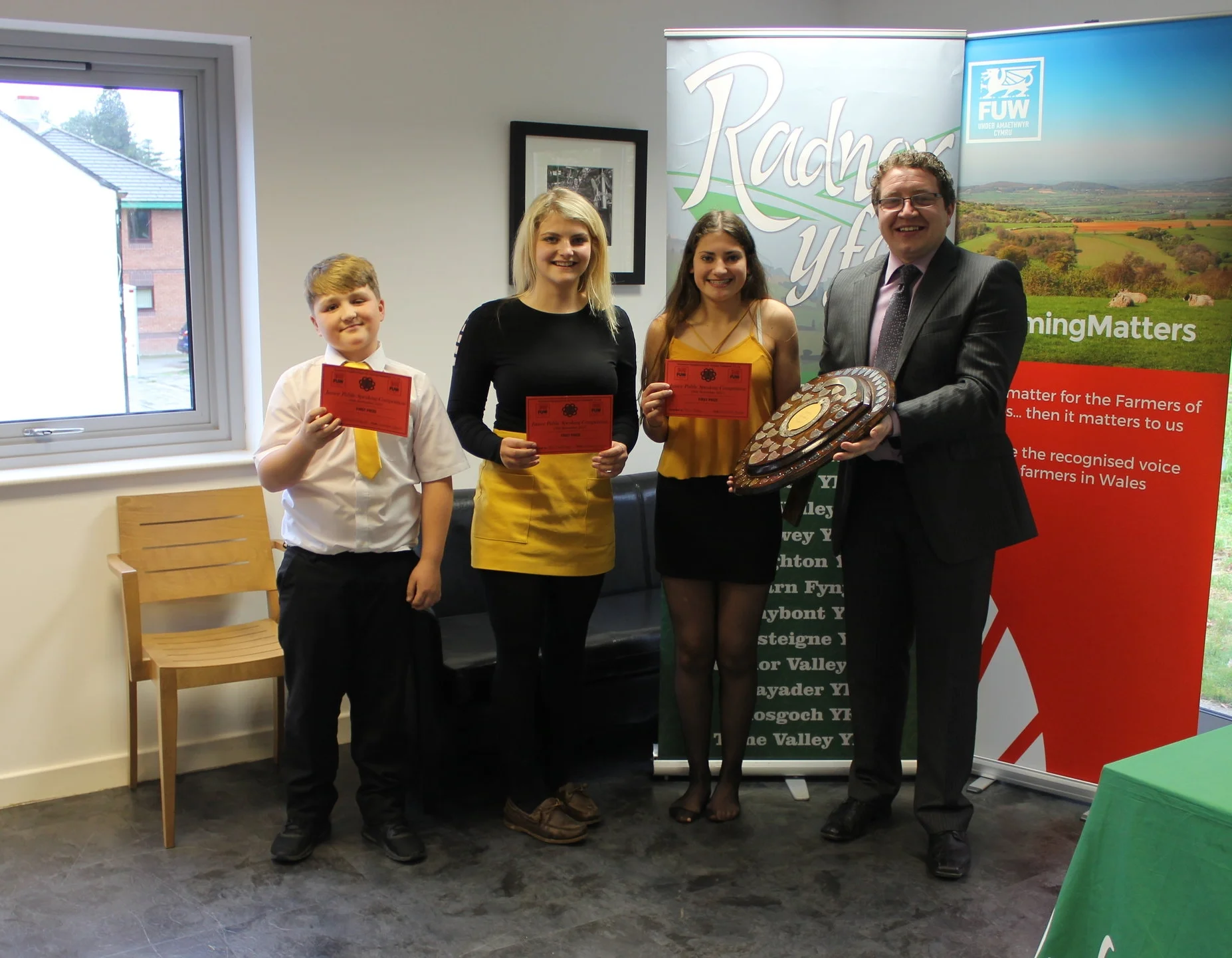 William Goodwin Edwards, Annie Fairclough and Rhian Hughes, Llanbadarn Fynydd YFC with judge Hefin Jones winning the Junior Public Speaking shield.